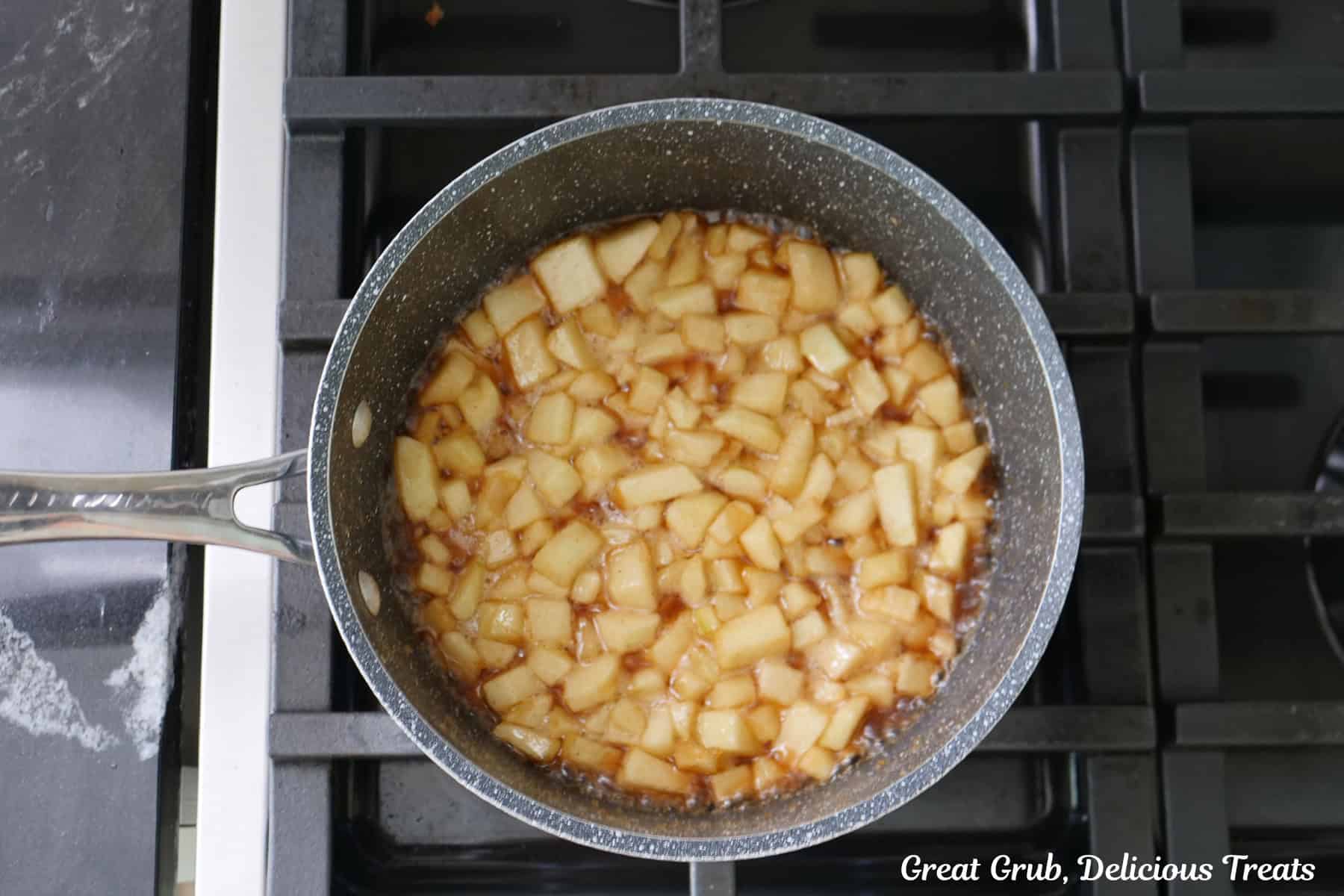 A saucepan on the stove with a homemade apple filling in it.