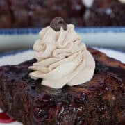 A black forest brownie on a white plate with whipped cream and a chocolate chip on top, and a title overlay at the top.