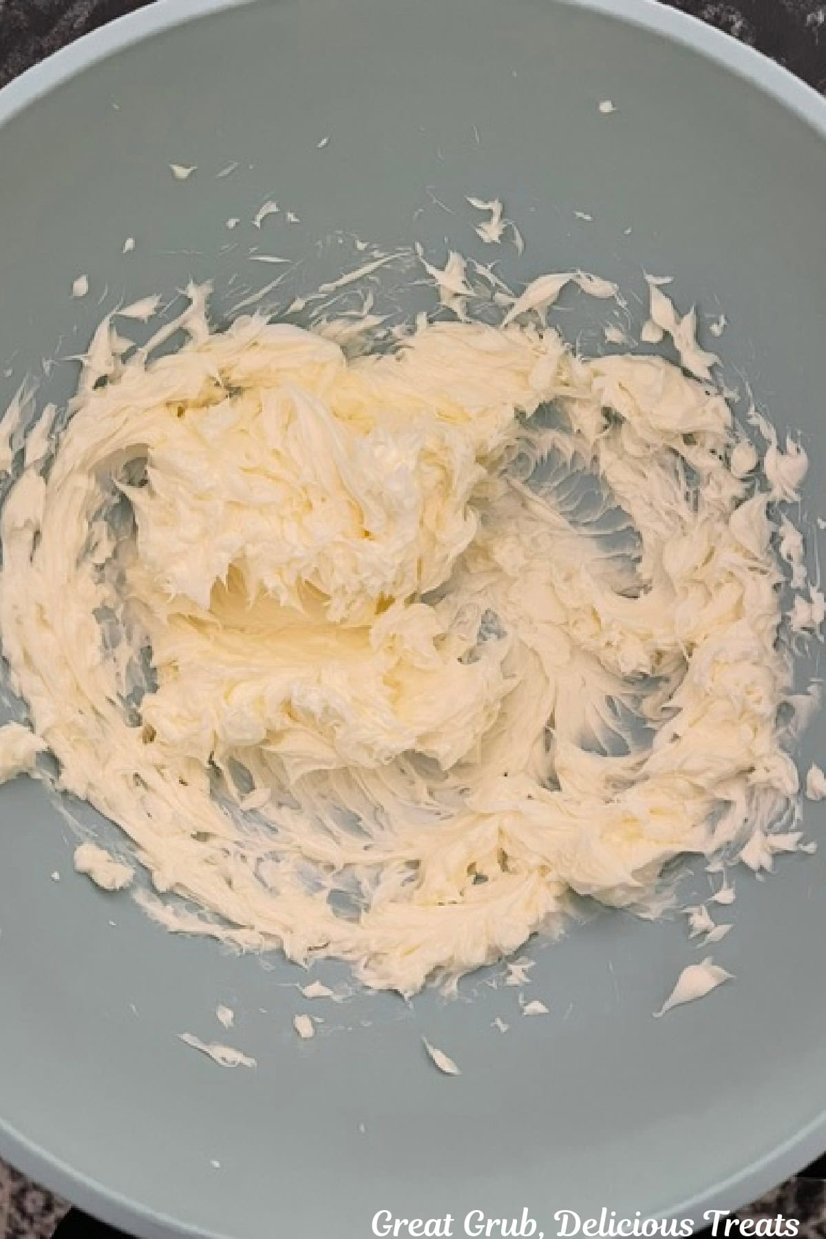 A light blue bowl with creamy butter in it.