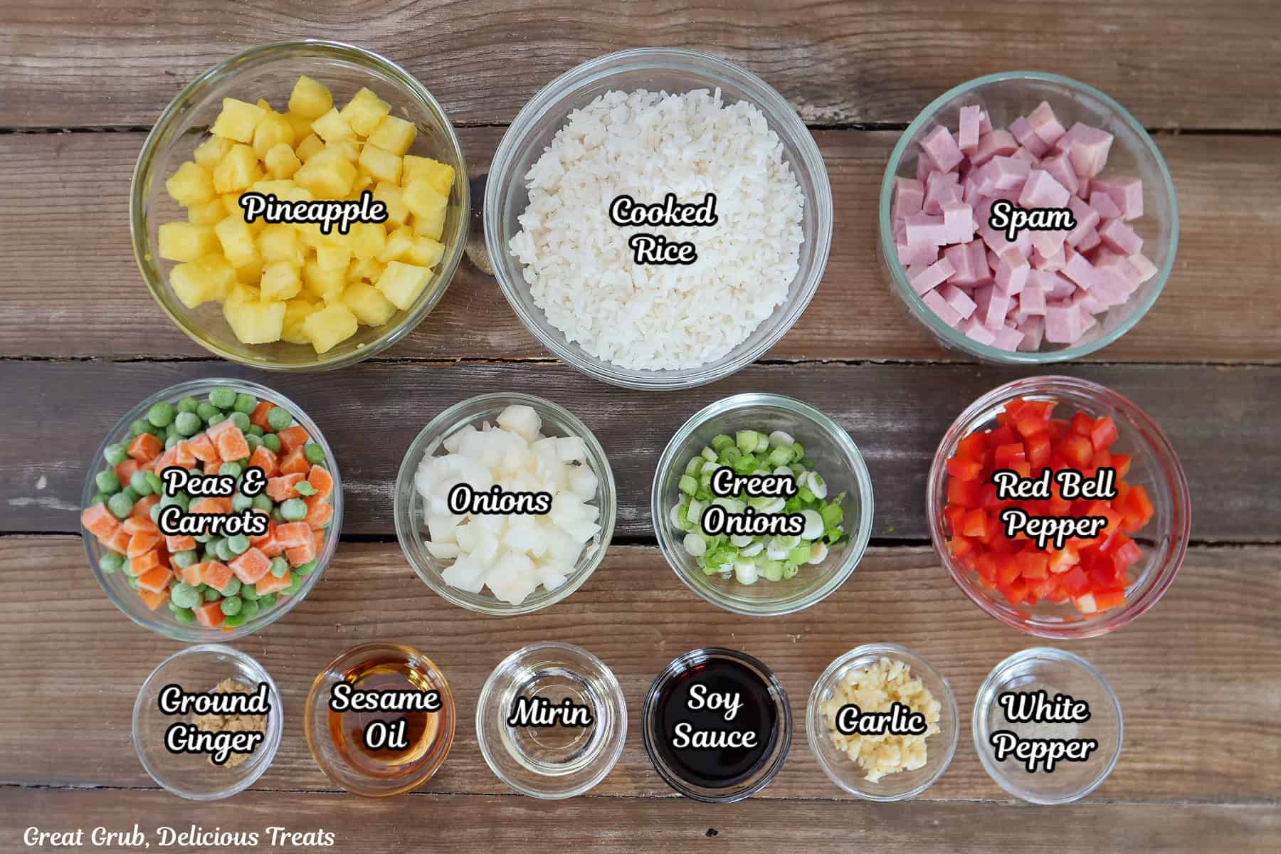 A wood surface with all the ingredients placed on it in bowls to make Hawaiian fried rice.