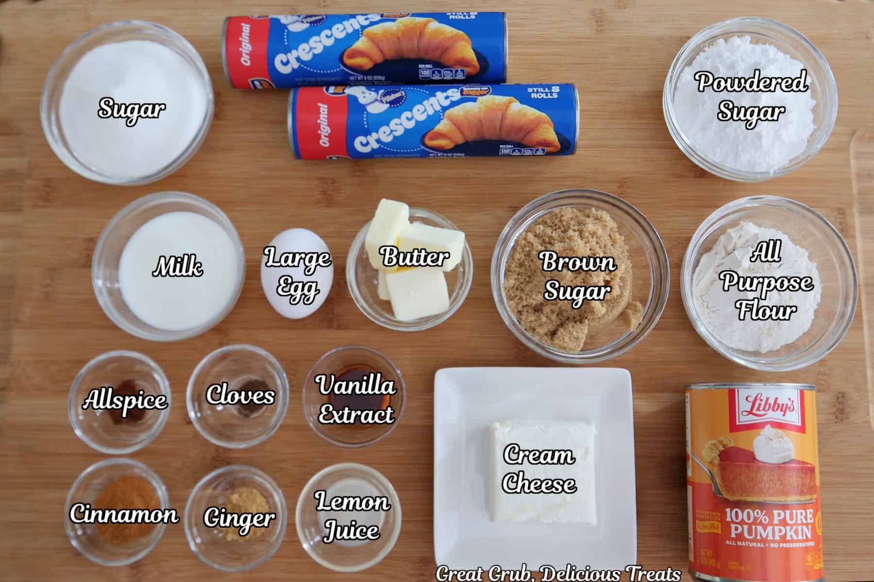 A wood surface with all the ingredients placed on it to make pumpkin streusel cream cheese muffins.