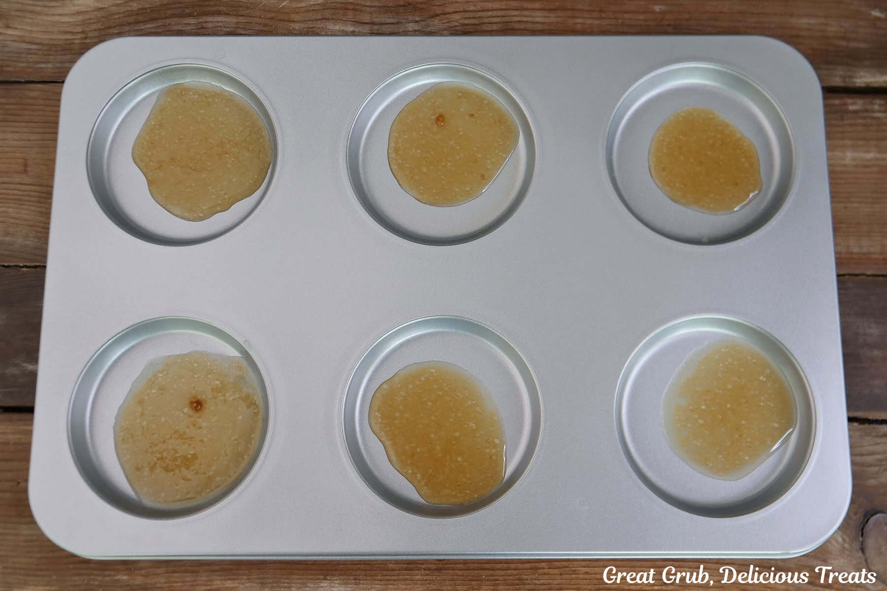 A silver pan with a brown sugar honey glaze in on it.