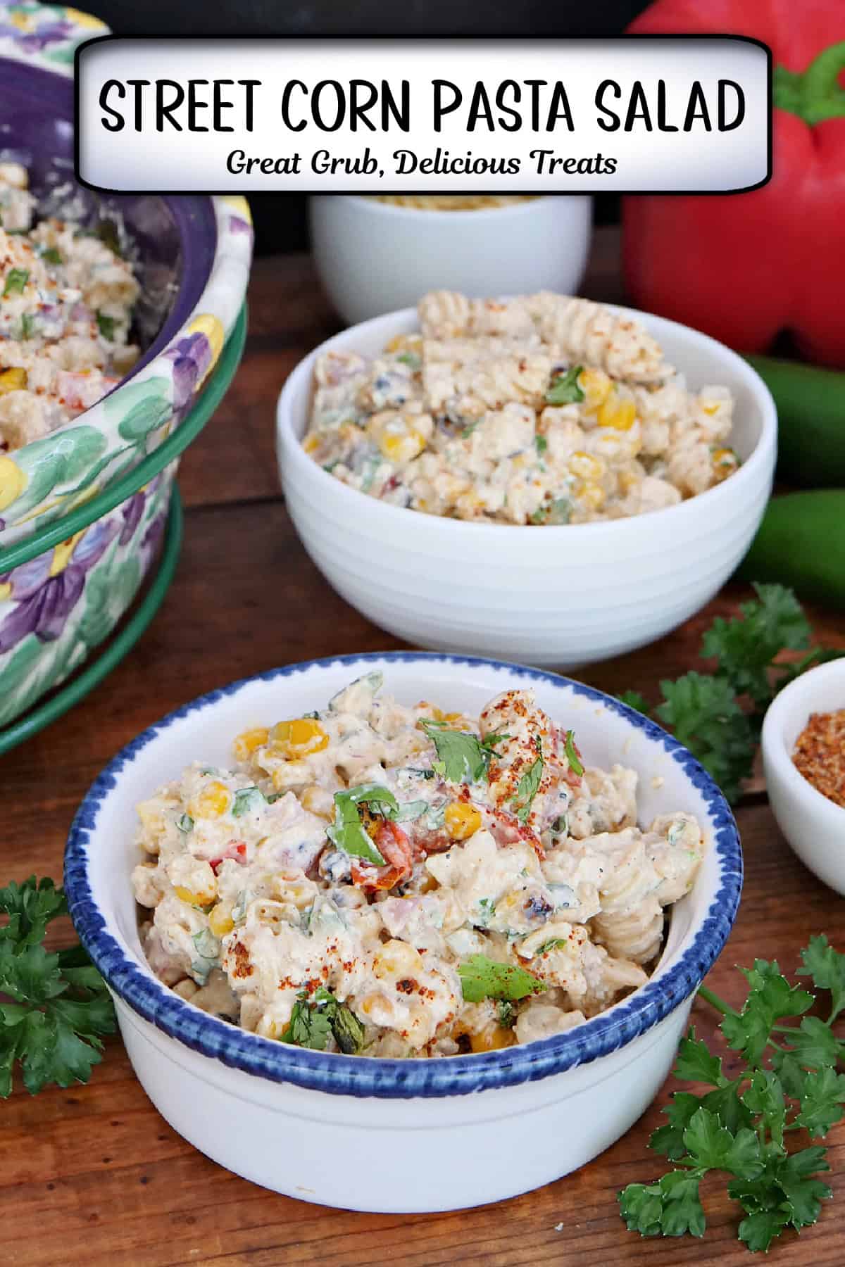 A wood surface with two white bowls filled with a serving of street corn pasta salad, and a title overlay at the top.