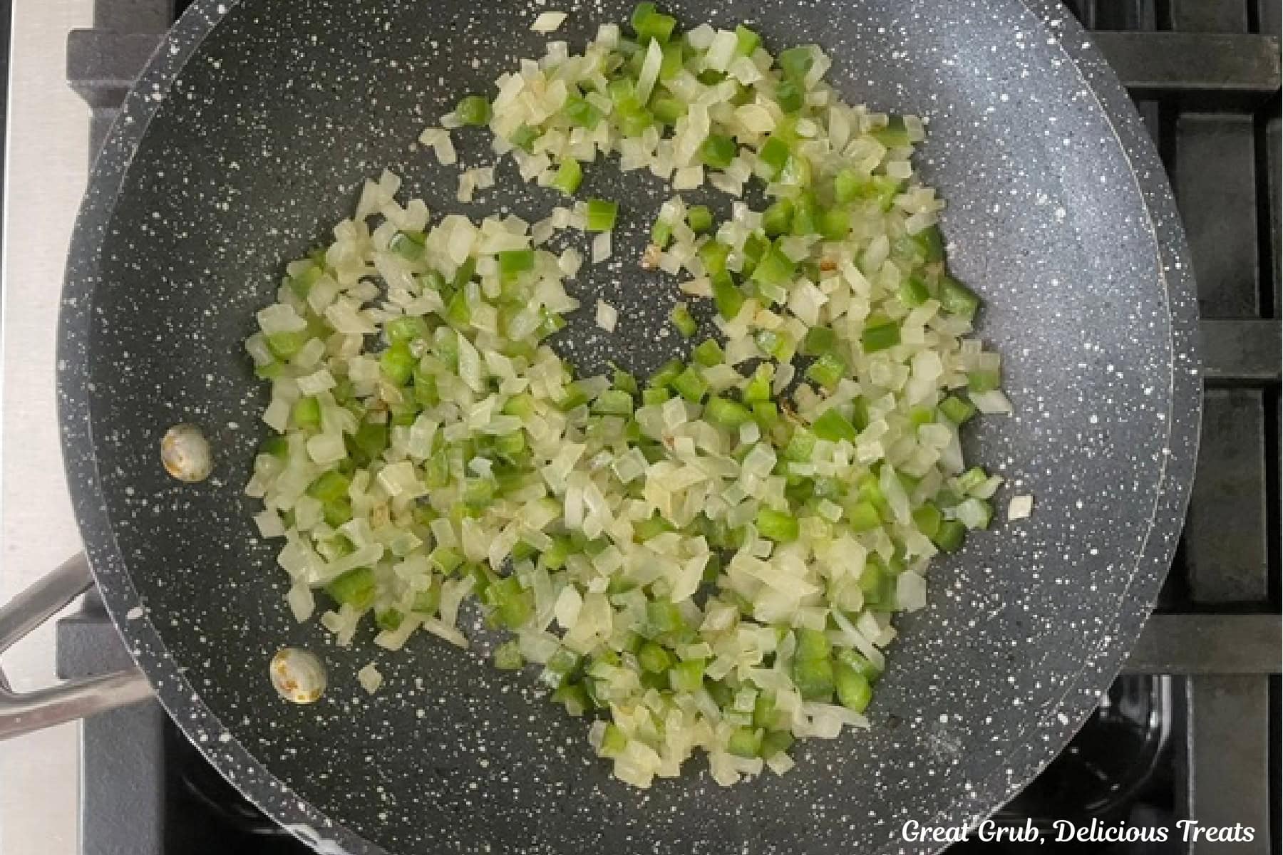 A frying pan with cooked diced jalapenos and onions.