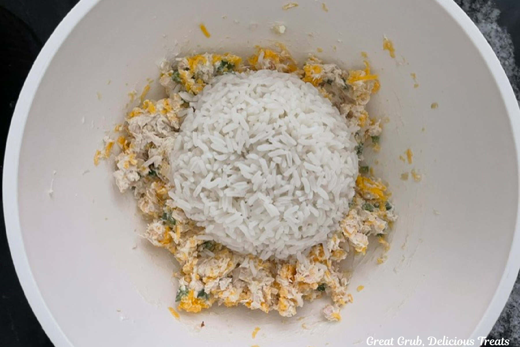 A white bowl with a cheesy chicken mixture with white rice added.