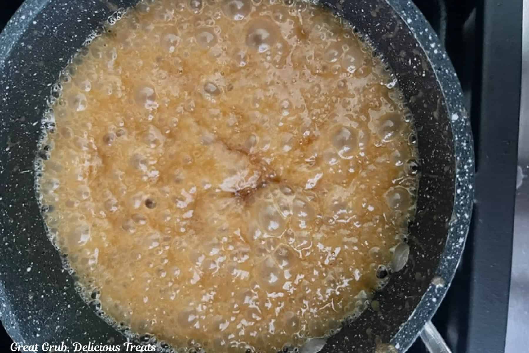 A saucepan with caramel filling boiling.