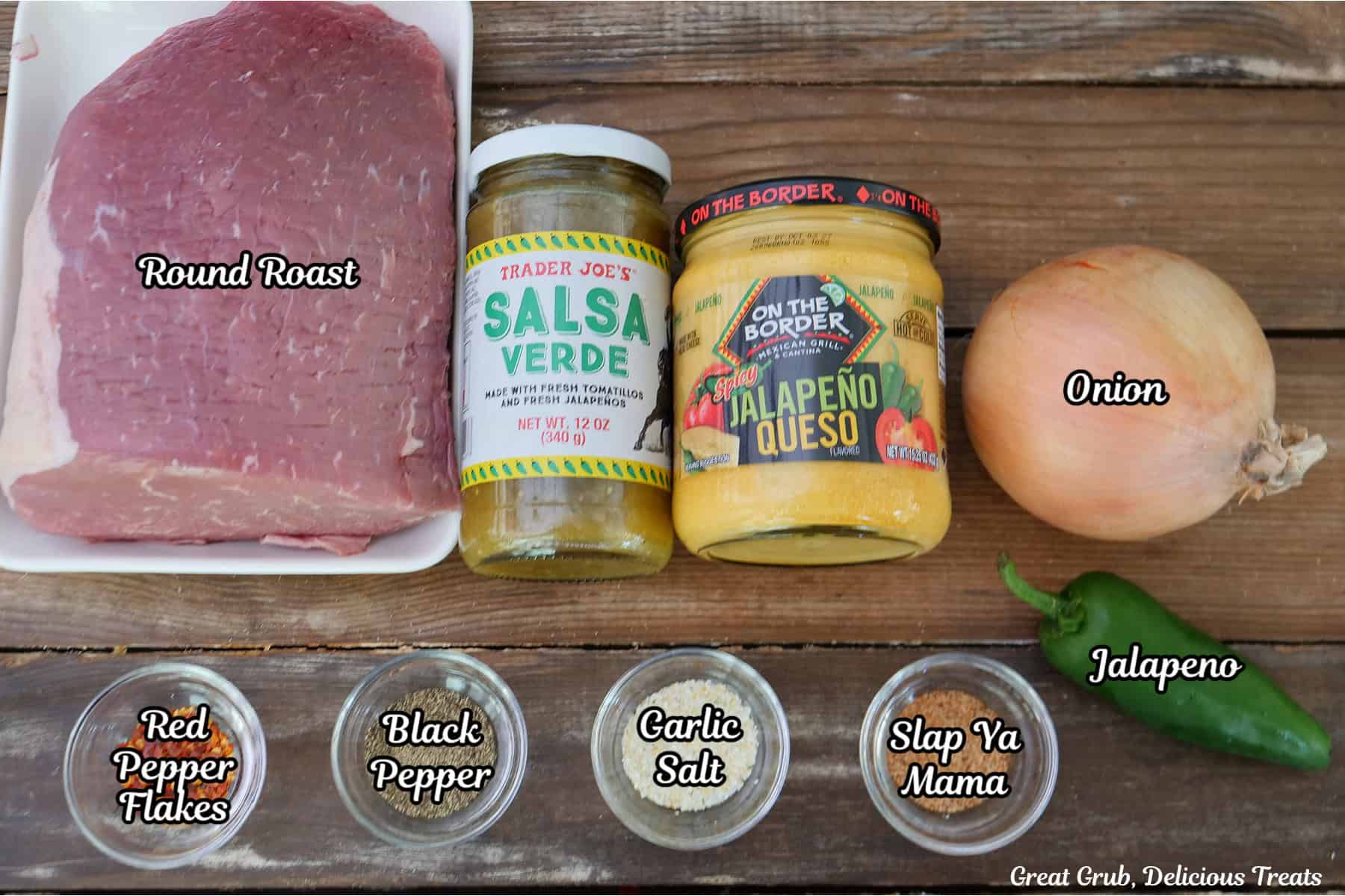 A wood surface with all the ingredients placed o it to make crockpot spicy queso roast beef.