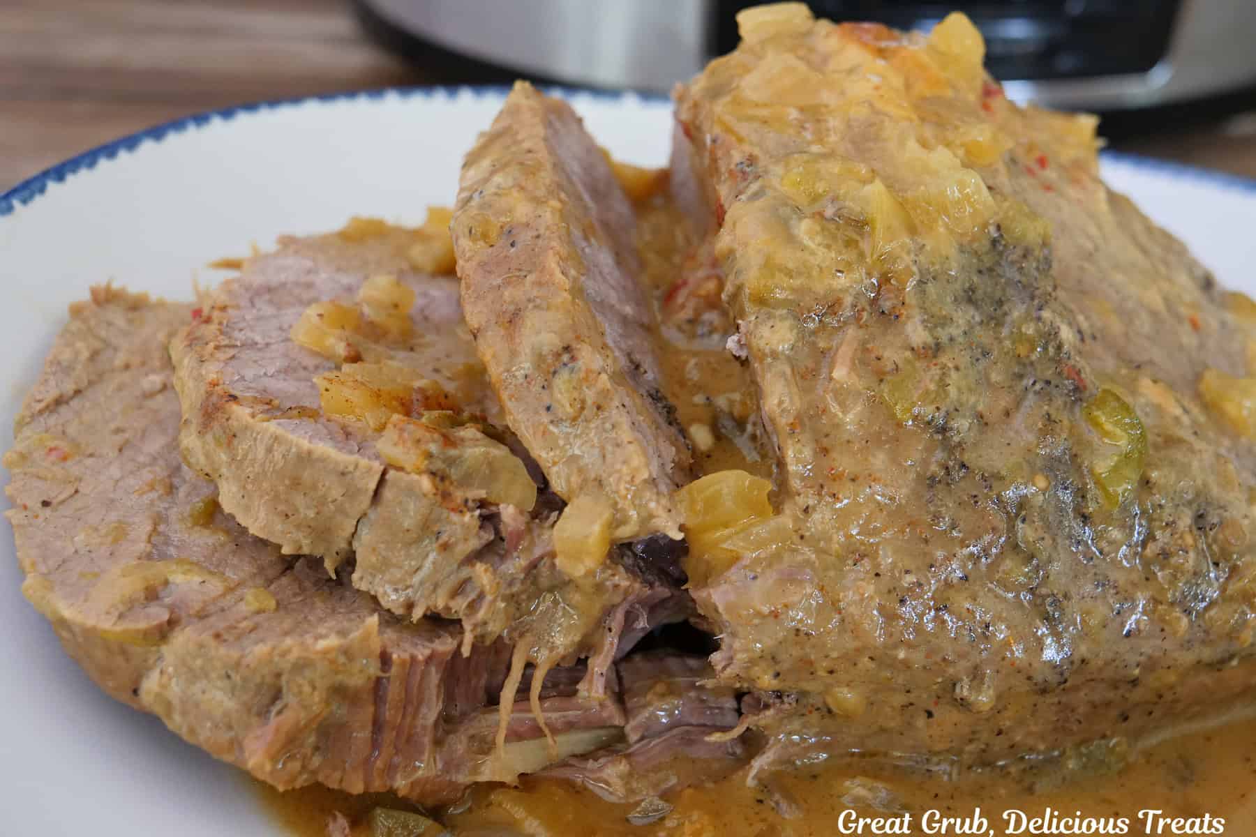 A white plate with blue trim with a slow cooked round roast on it.