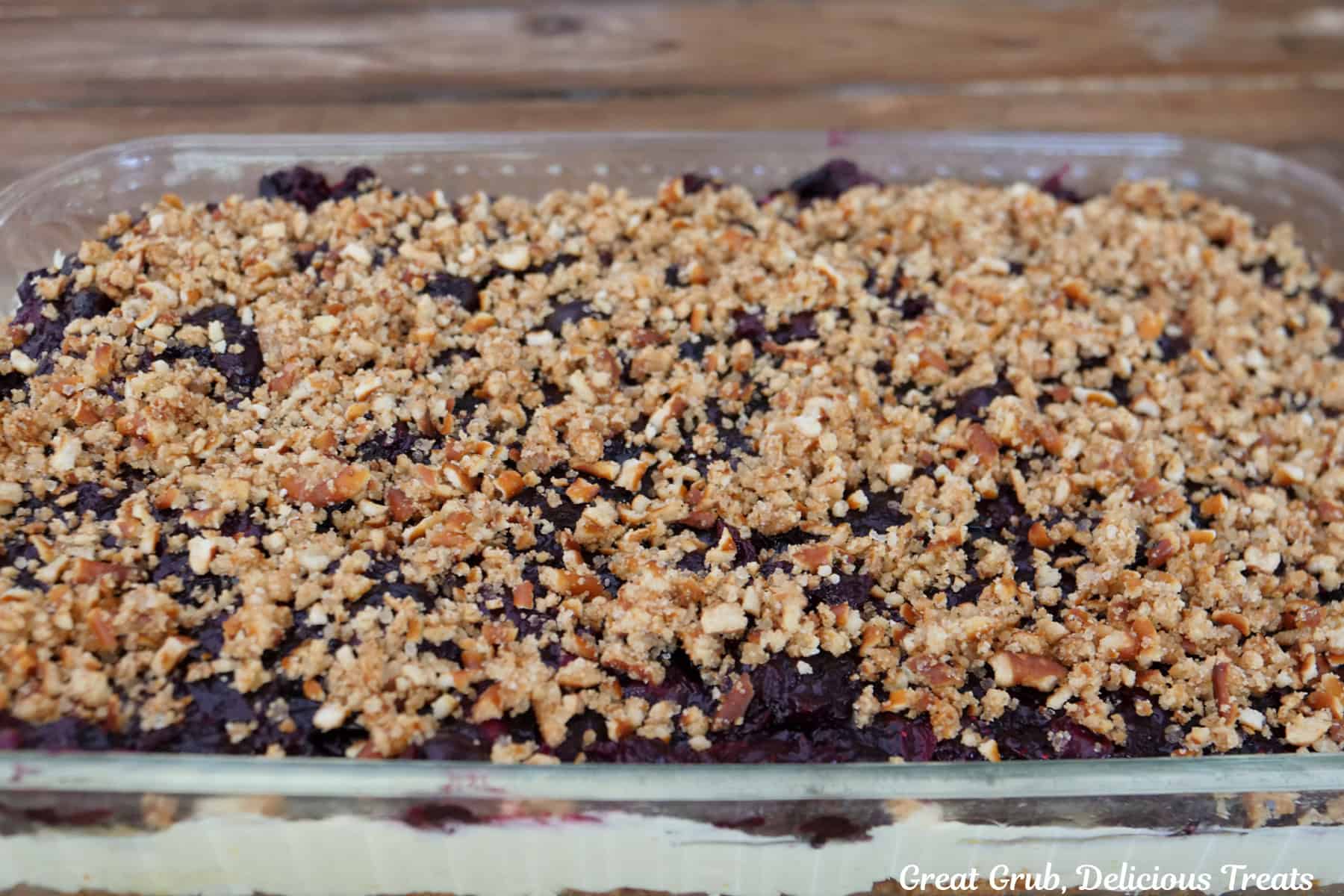 A glass 9 by 13 baking dish filled with lemon blueberry pretzel salad in it.