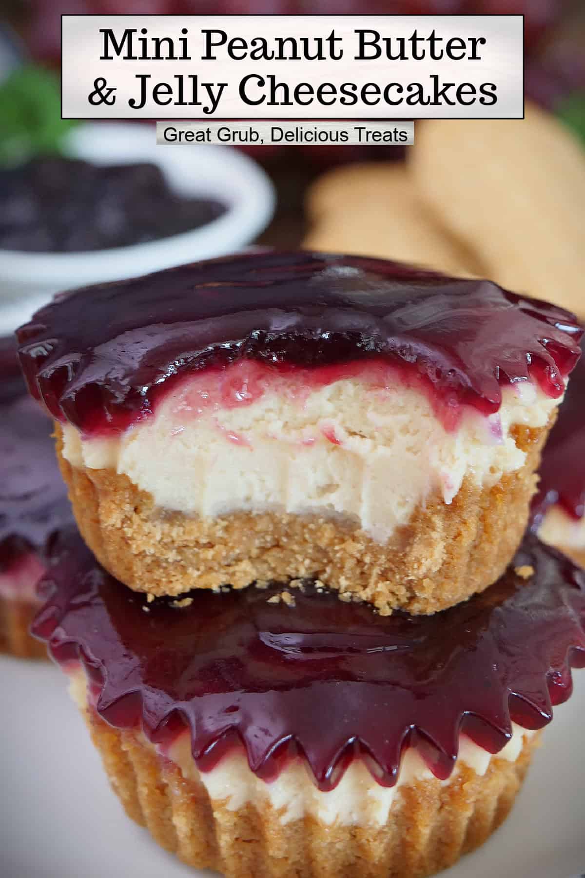 Two mini peanut butter and jelly cheesecakes stacked on top of each other with a bite taken out of the one on top, and a title overlay at the top.