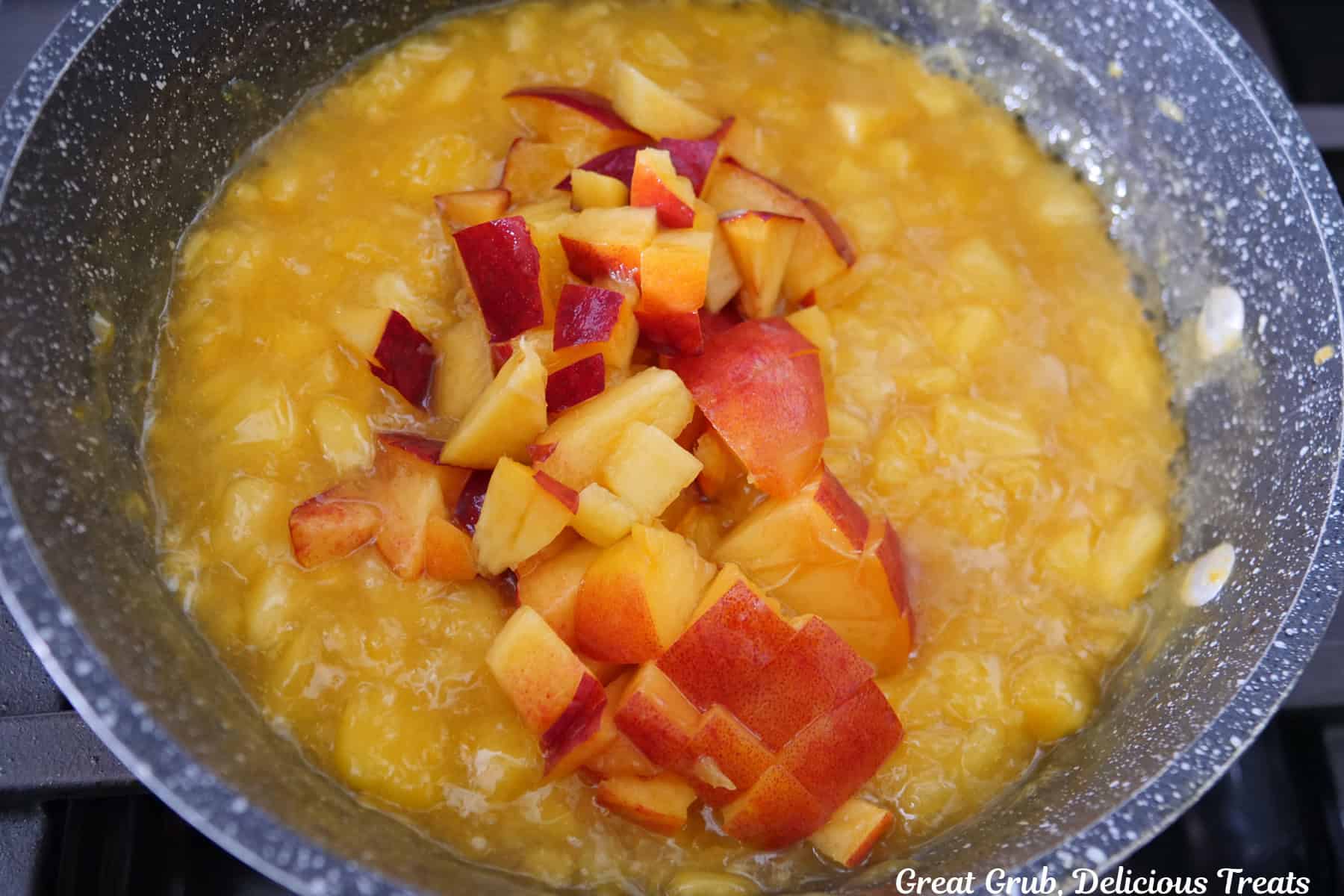 A saucepan with thickened cooked peaches in it.