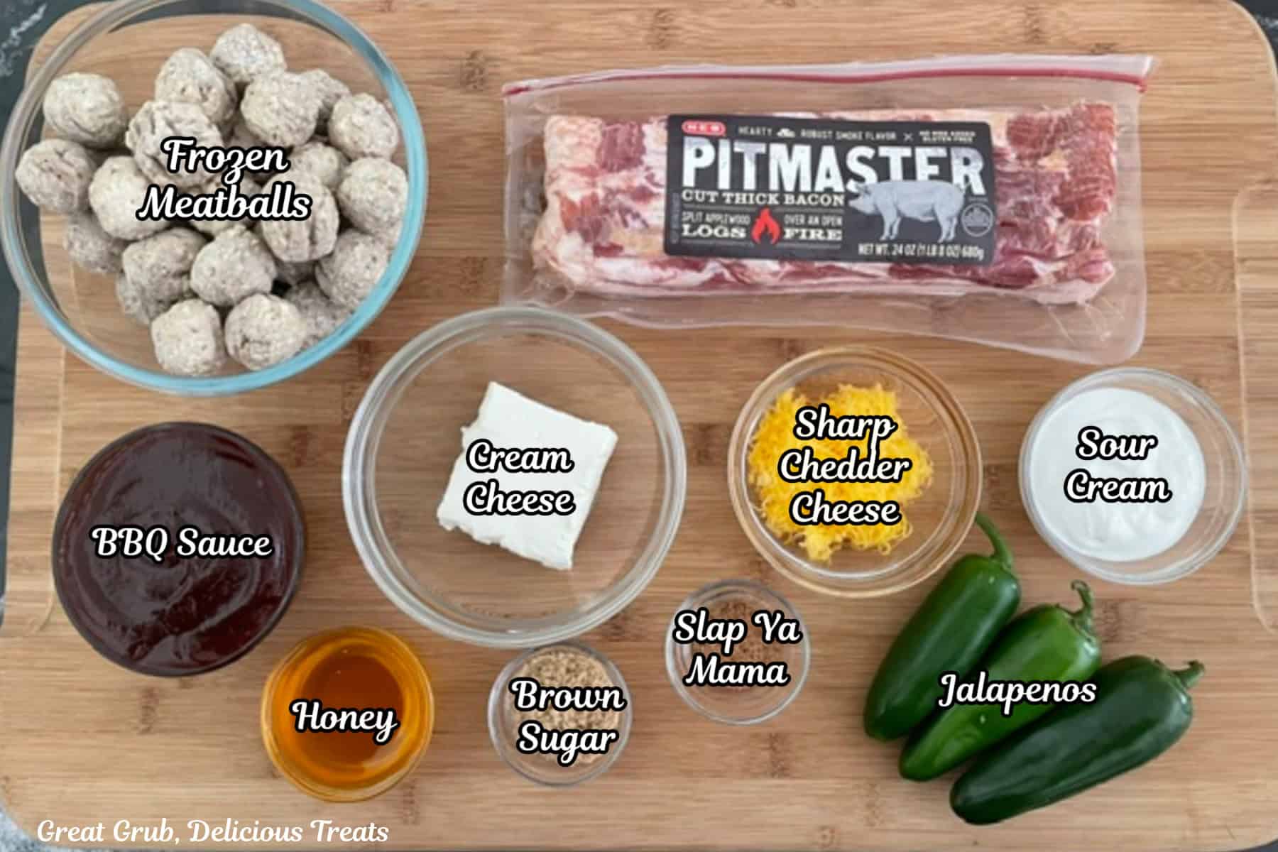 A wood surface with all the ingredients placed on it to make smoked meatball pig shots.