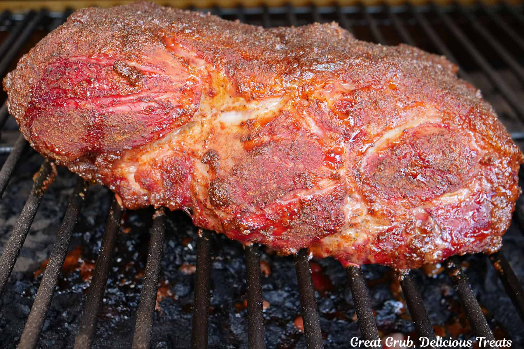 A smoked pork roast on the smoker grill grates.