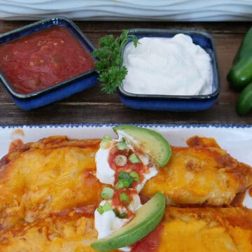 A white plate with blue trim with two shredded beef enchiladas on it with a title overlay at the top.