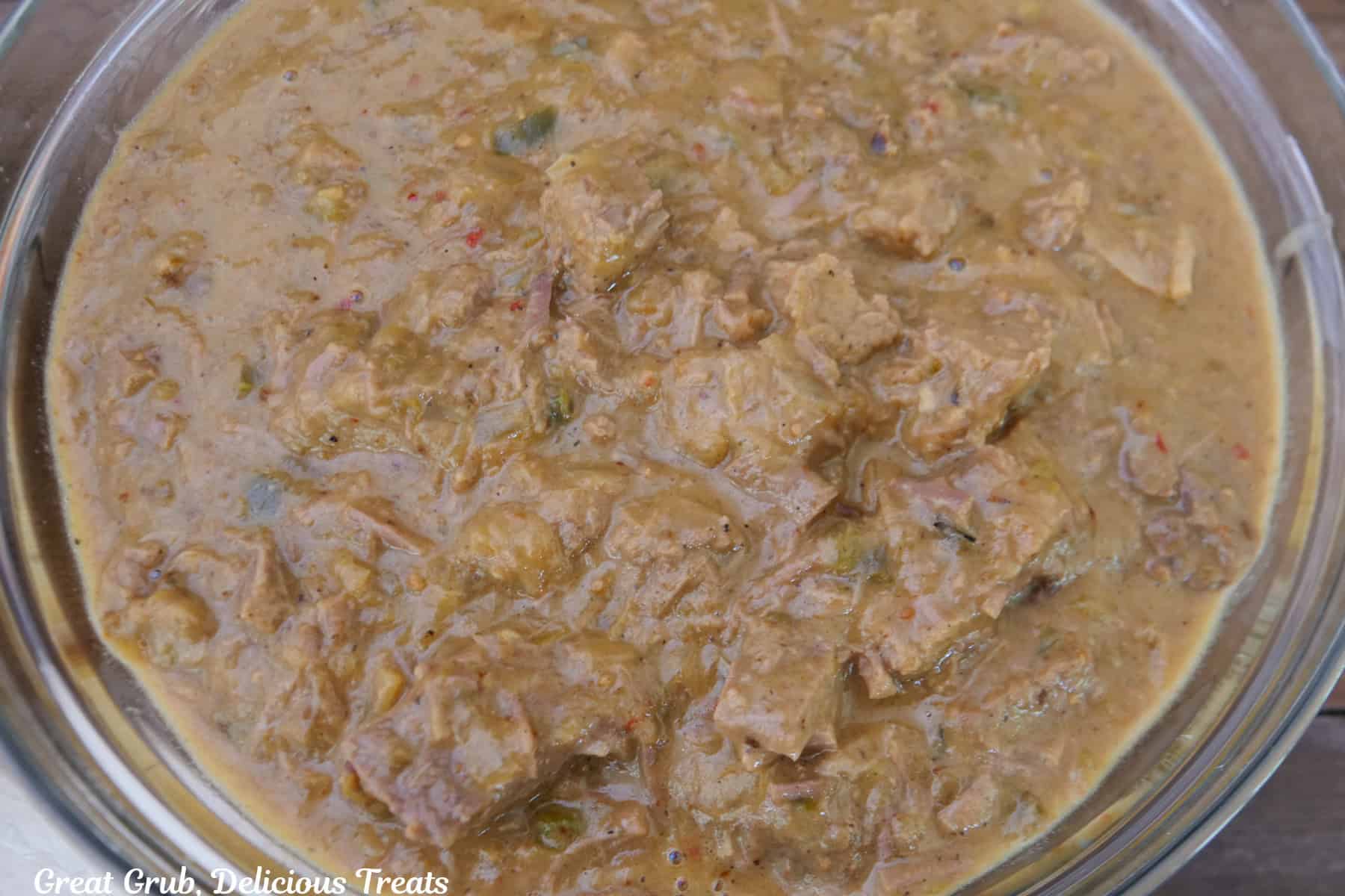 A glass bowl filled with shredded beef mixture in it.