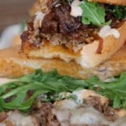 A steak sandwich stacked on top of another steak sandwich, and a title overlay at the bottom