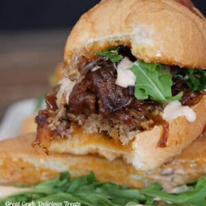 A steak sandwich with a bite taken out of the end of it.