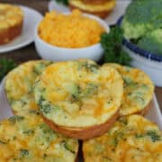 A white plate with a stack of five broccoli cheddar egg bites on it with a bite taken out of the one on top, and a title overlay at the top.