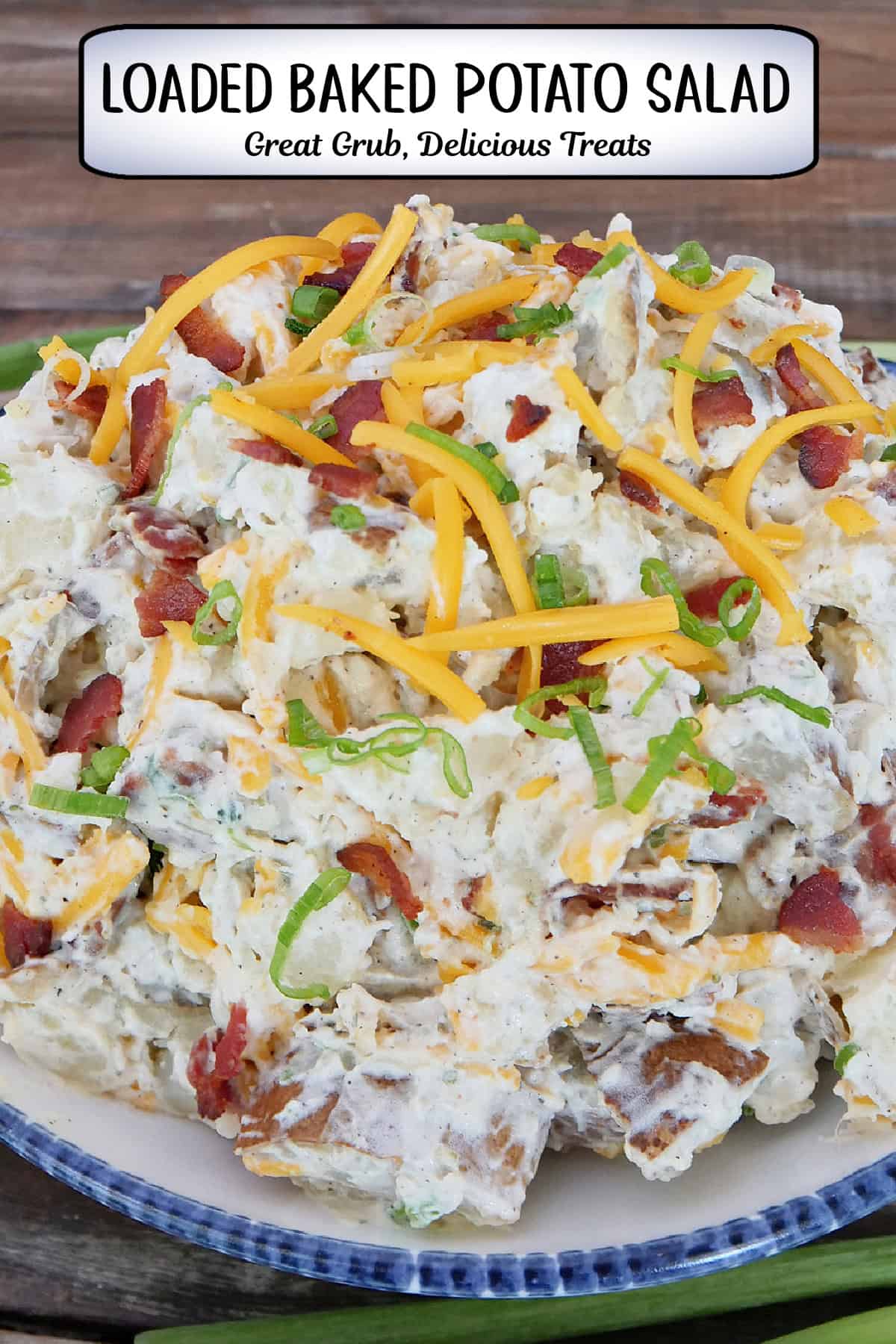 A rustic wood surface with a big bowl of loaded baked potato salad in it with a title overlay at the top.
