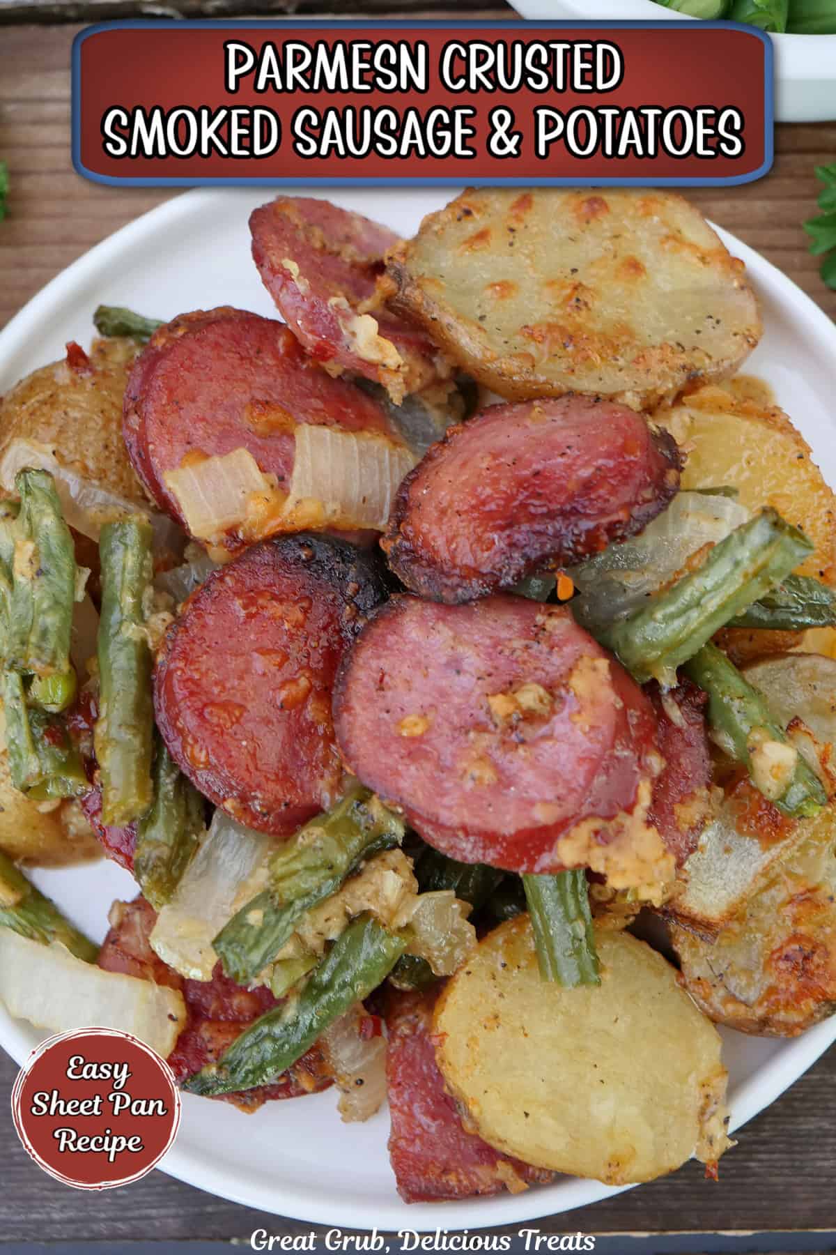 A white small round plate with a serving of Parmesan crusted smoked sausage, potatoes, and green beans on it, and a title overlay at the top.