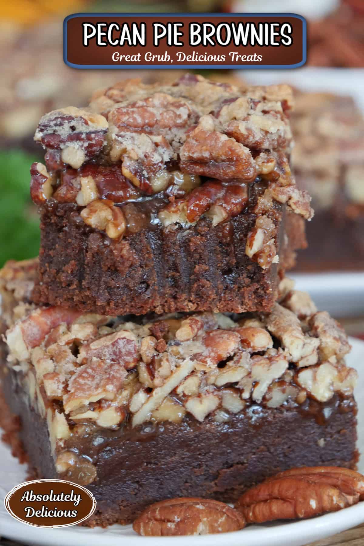 Two pecan pie brownies on a white plate stacked on top of each other with a bite taken out of the one on top, and a title overlay at the top.