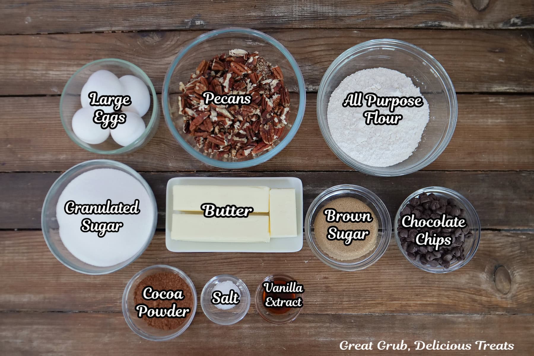 A wood surface with all the ingredients placed on it to make pecan pie brownies.