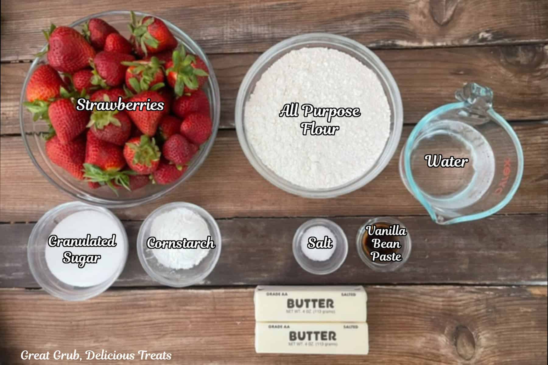 A rustic surface with all the ingredients placed on it to make strawberry pie bars.