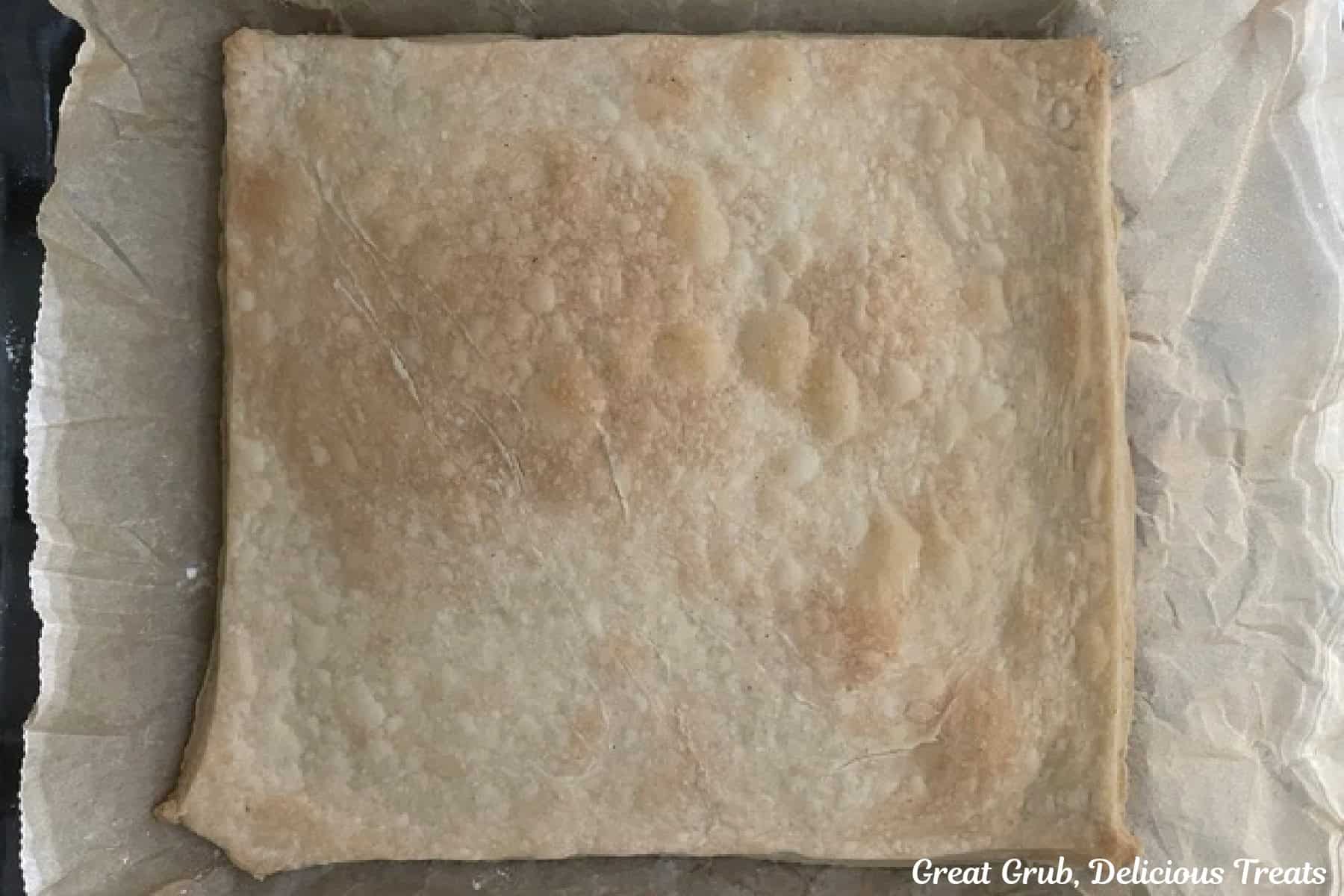 An 8 by 8 glass baking dish with a baked bottom pie crust in it.