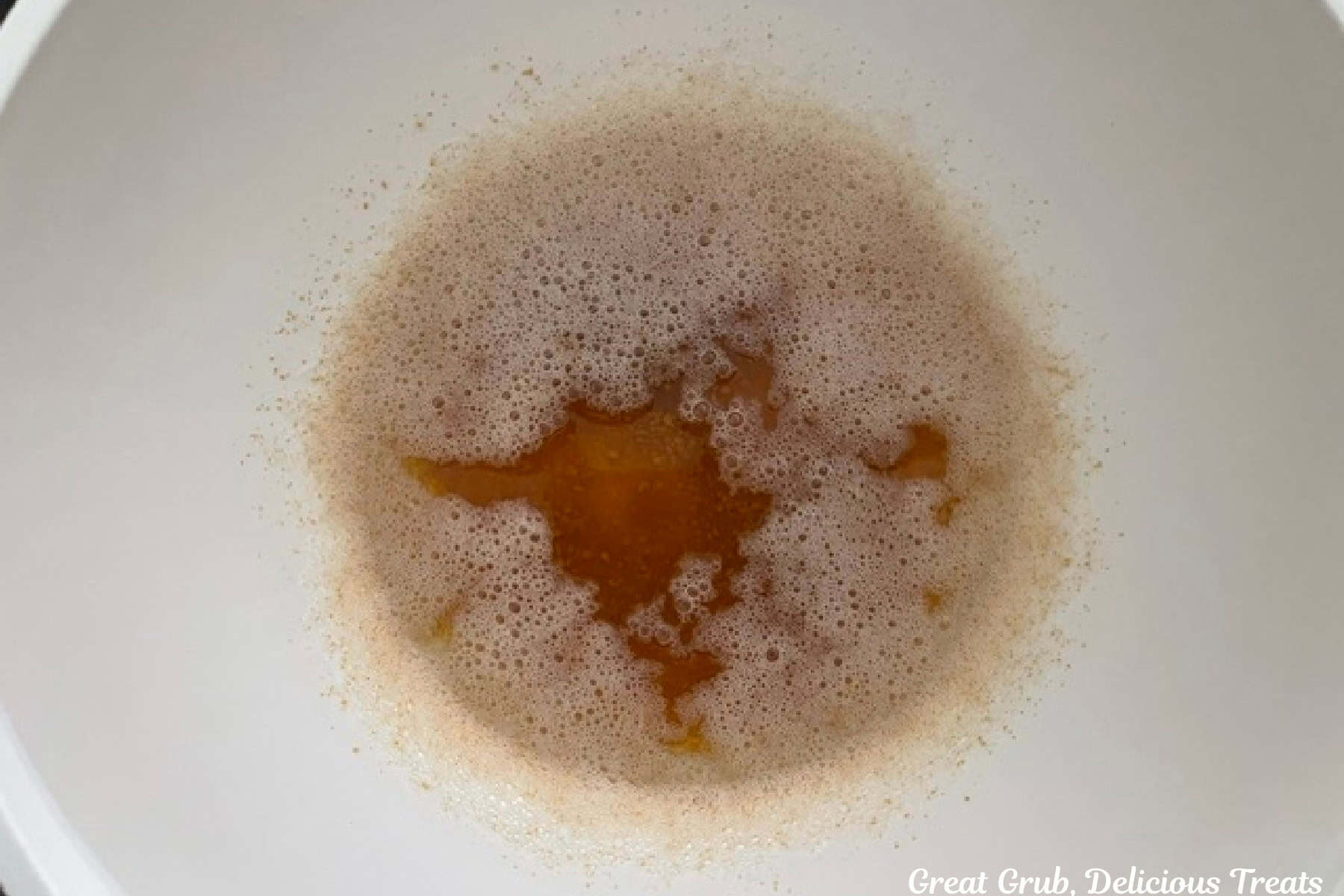 A mixing bowl with brown butter in it cooling.