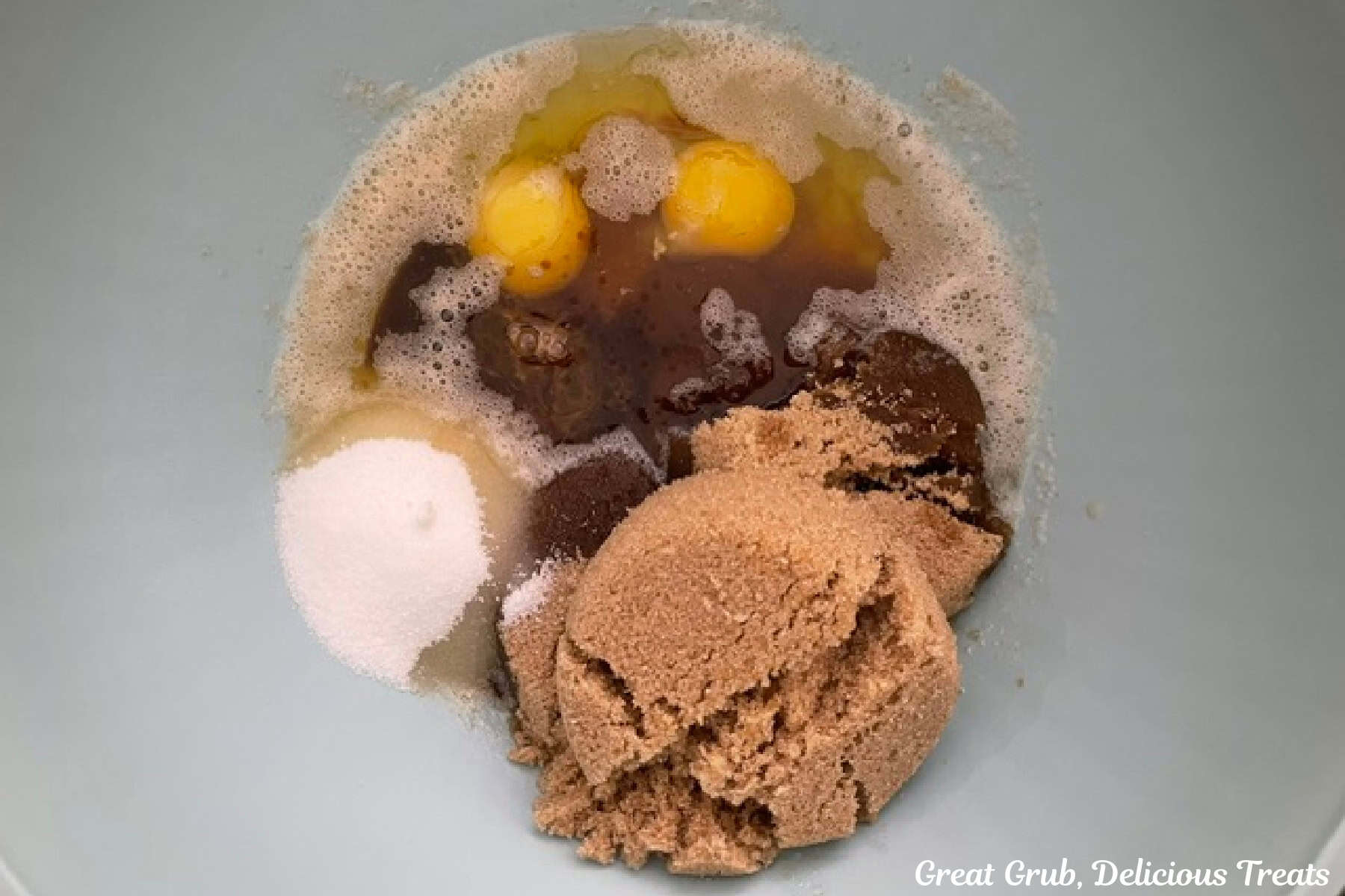 A mixing bowl with the brown butter and all the wet ingredients in it before being mixed together.