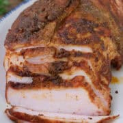 A blue trimmed white plate with a smoked Cajun turkey breast on it with a few slices cut, and a title overlay at the top.