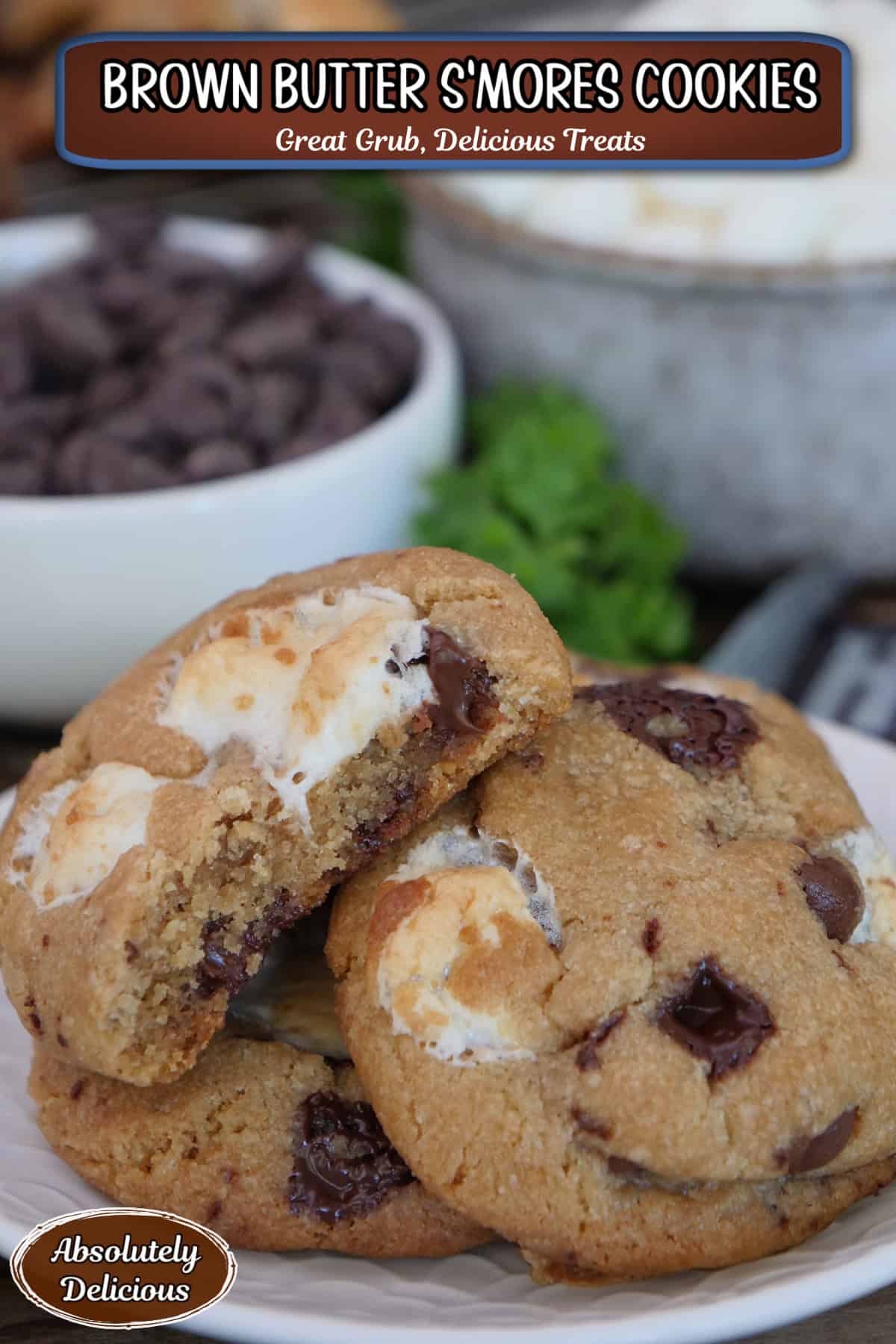 A white plate with three brown butter s'mores cookies on it with a bite taken out of the cookie on top, and a title overlay at the top.