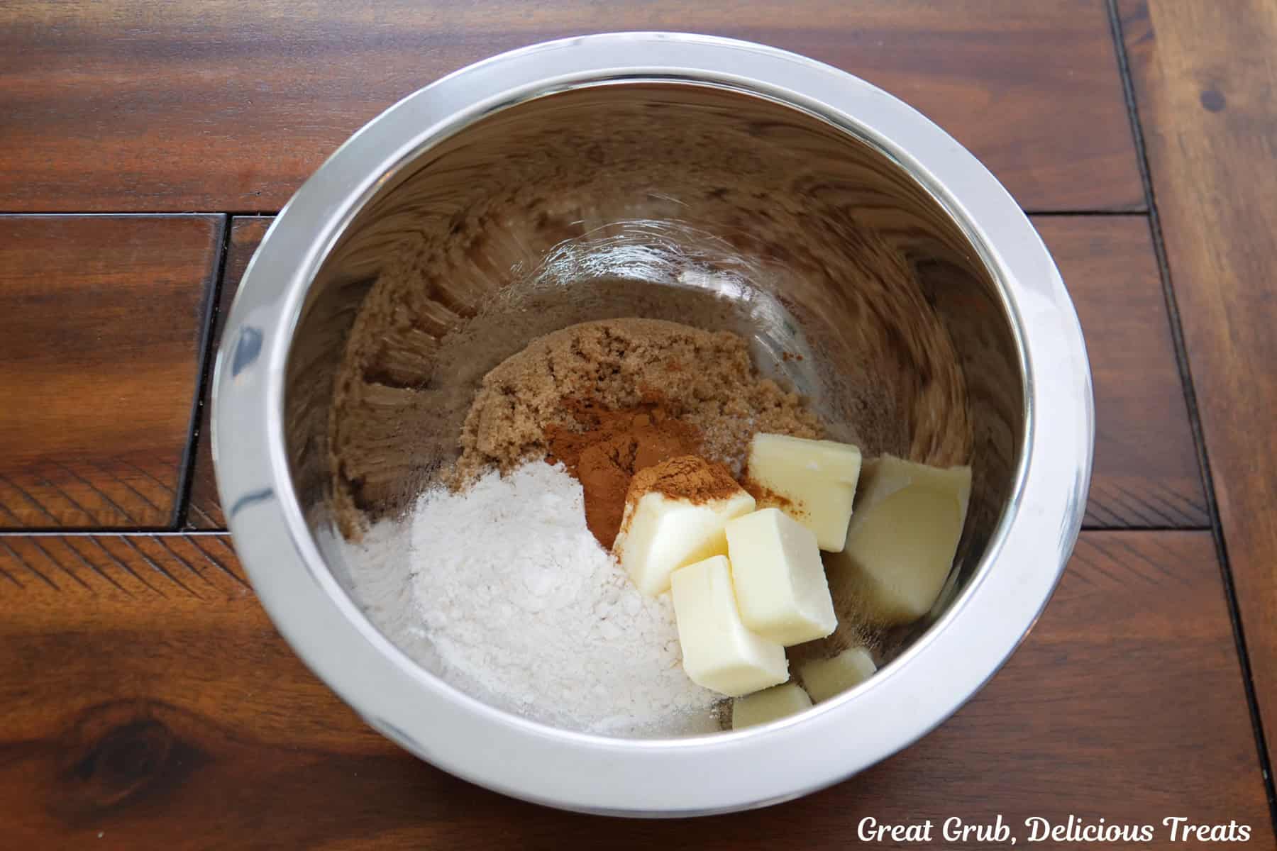 A sliver mixing bowl with streusel ingredients in it before being mixed together.