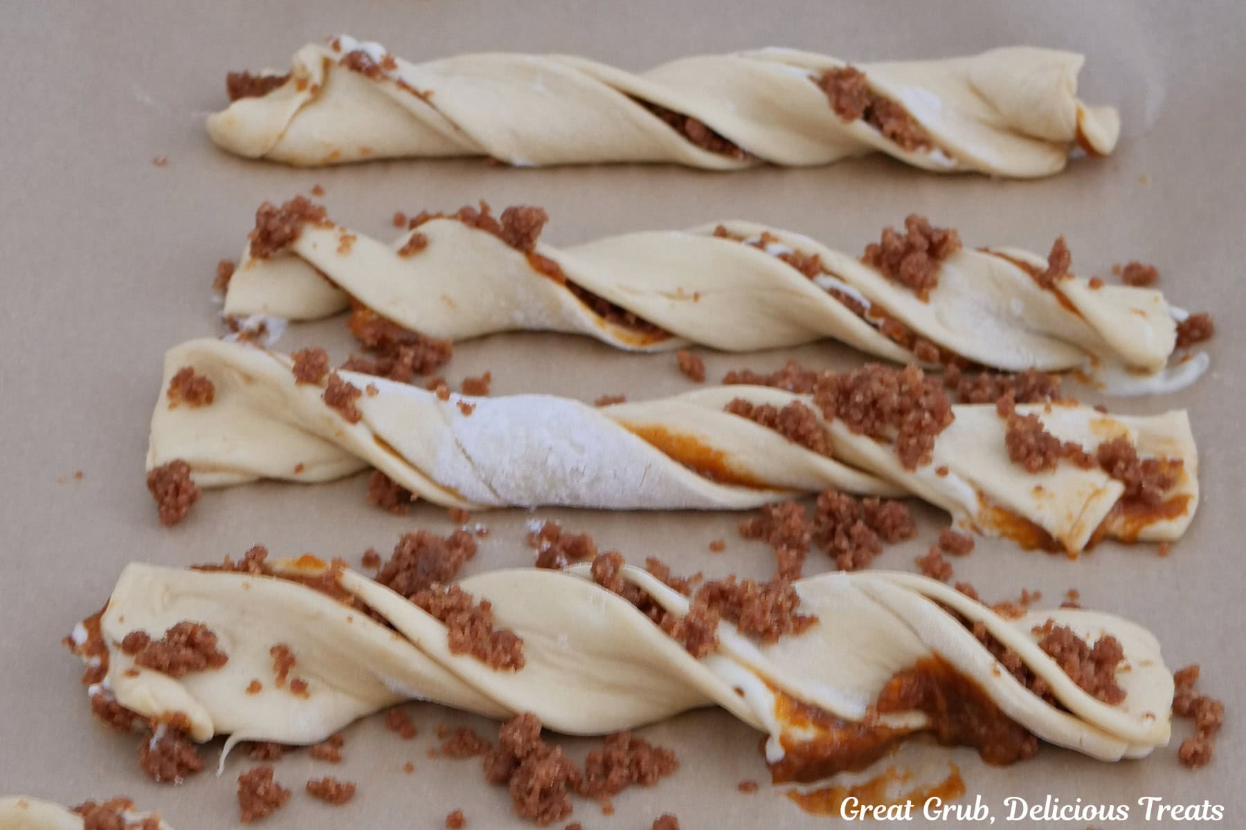 Four crescent dough strips twisted and filled with pumpkin cream cheese streusel.