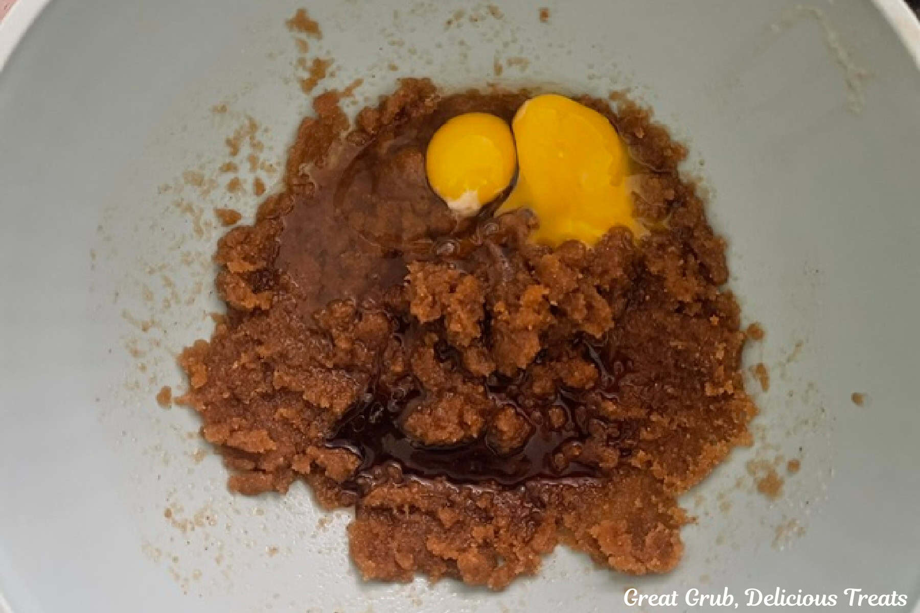 A white mixing bowl with wet blondie ingredients in it before being combined.