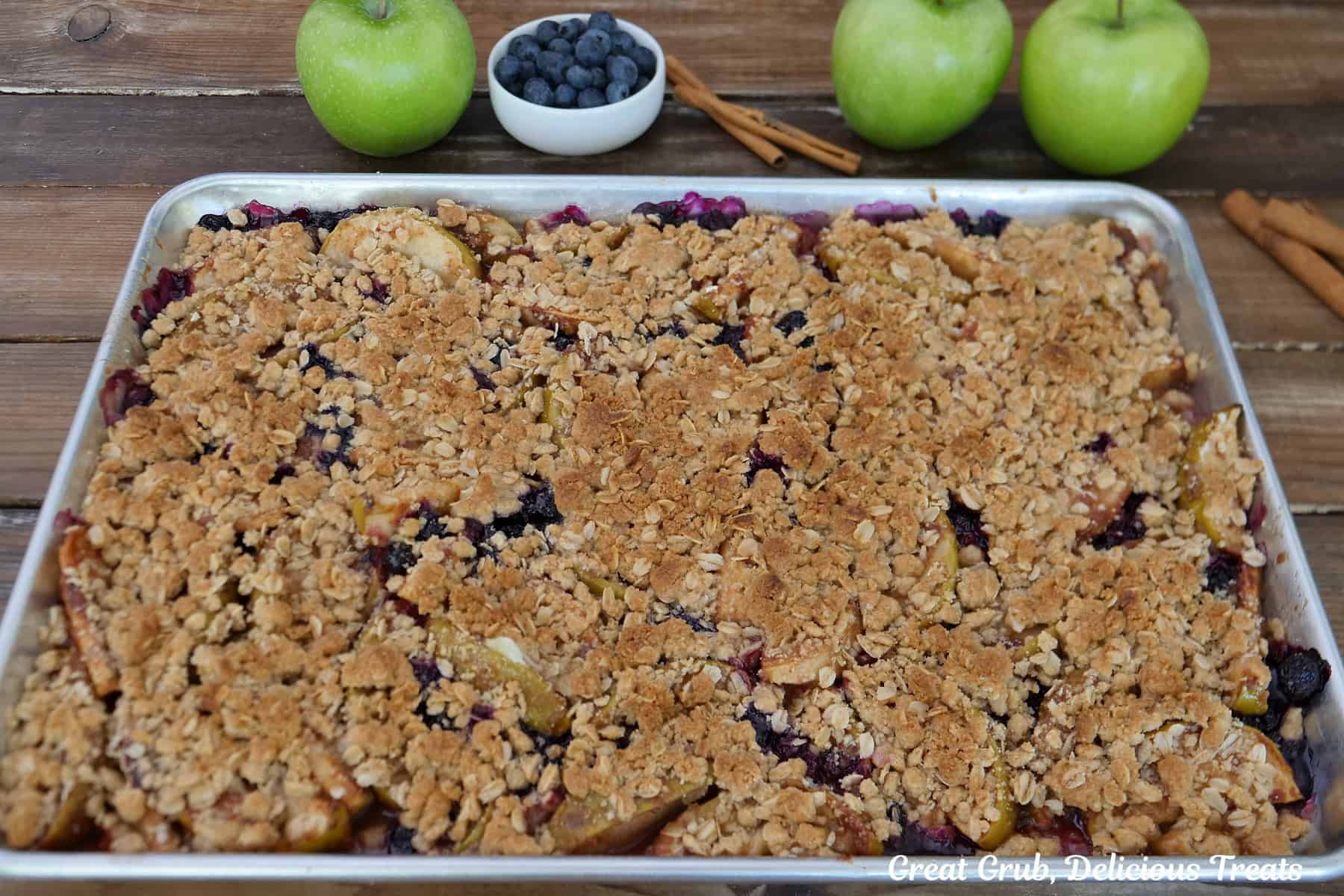A baking sheet with apple blueberry crisp on it after being baked.