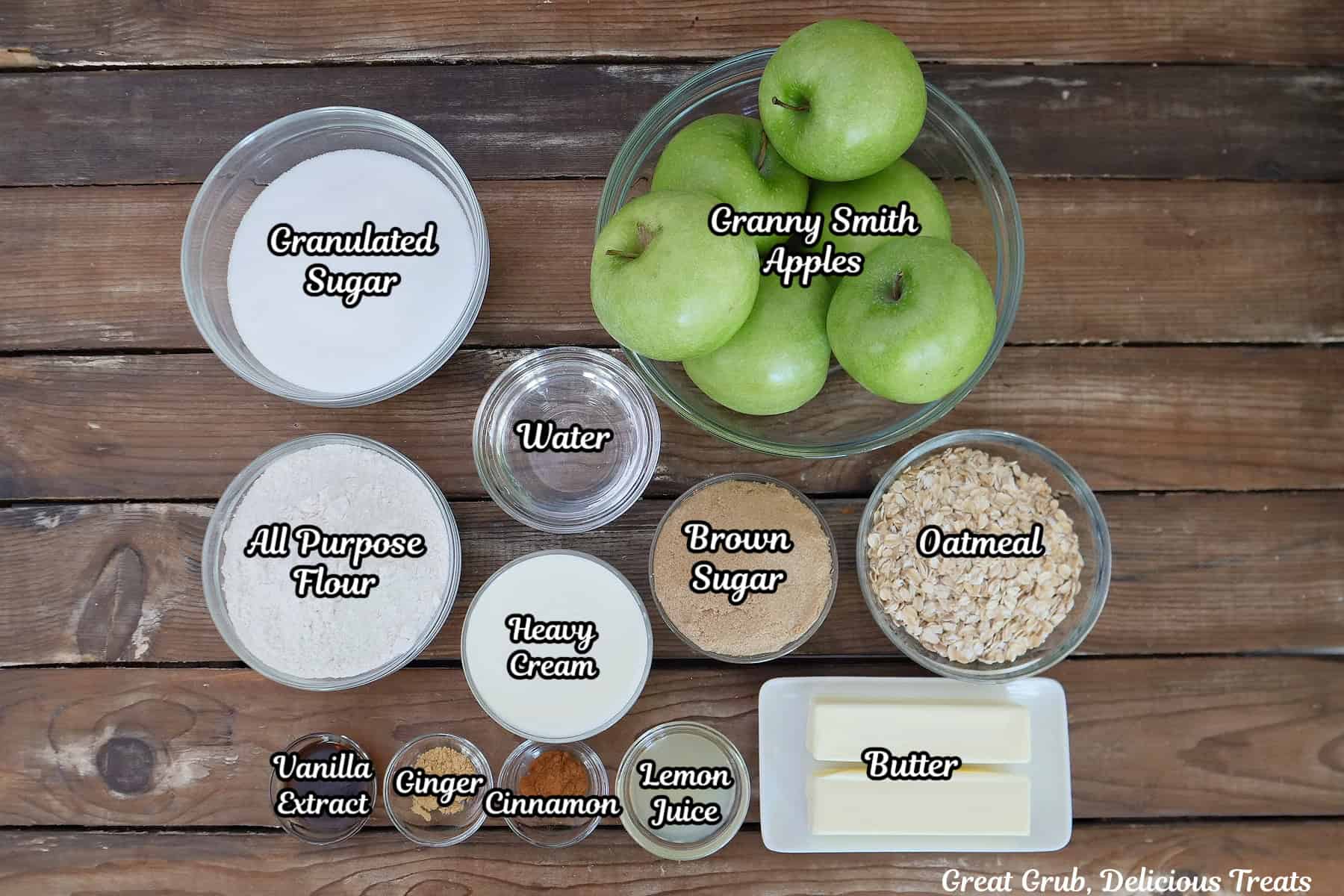 A wood surface with all the ingredients placed on it to make sheet pan caramel apple crisp.