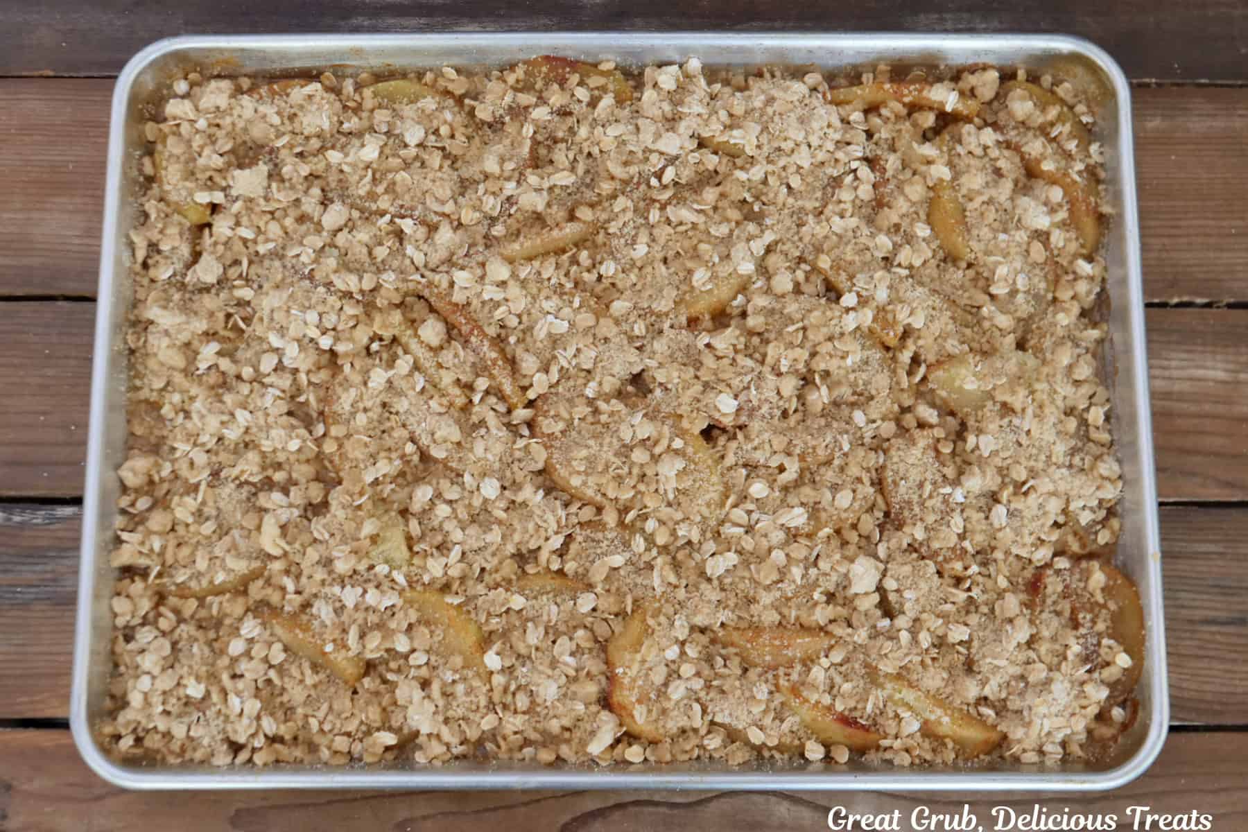 A sheet pan with the assembled caramel apple crisp on it before being baked.