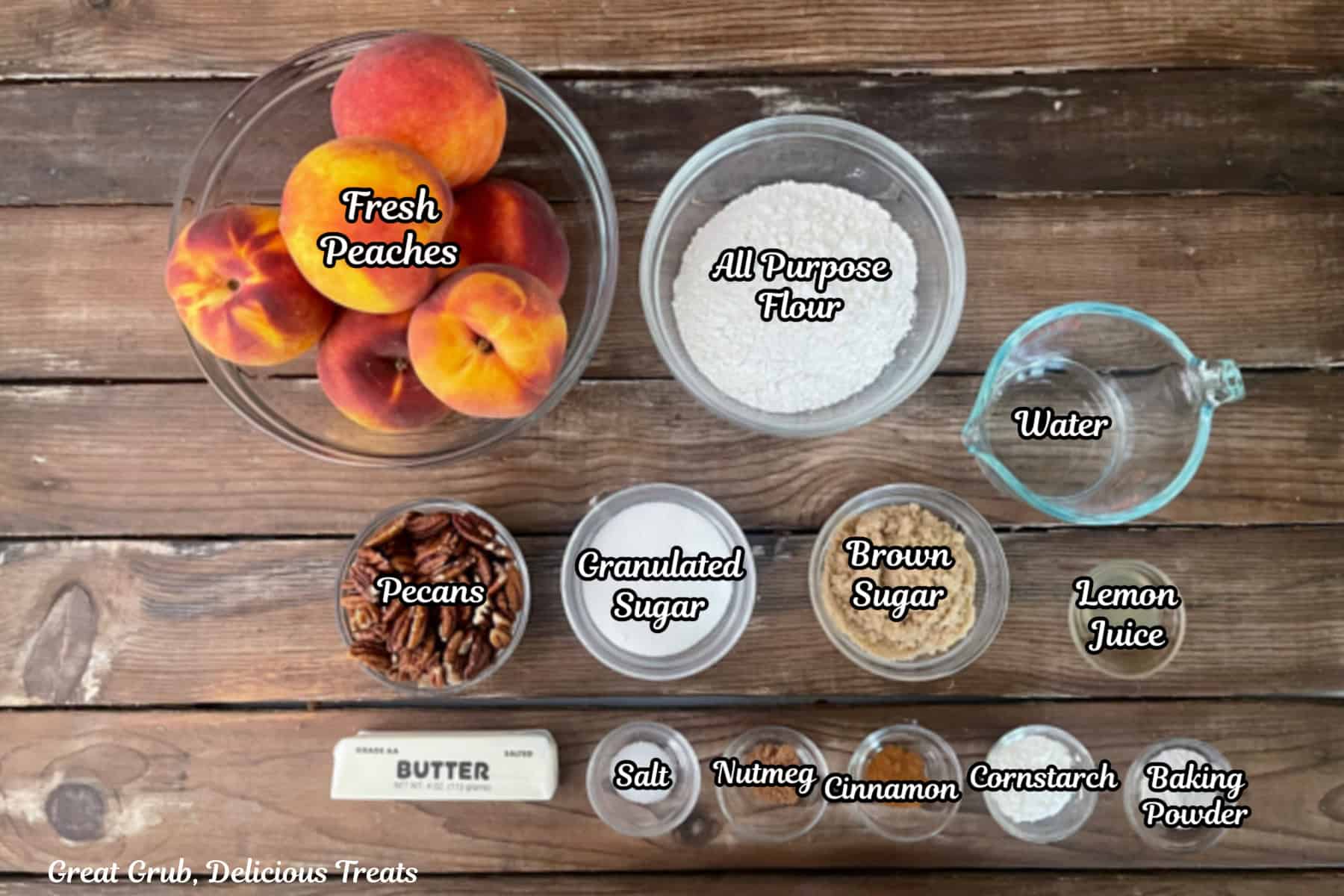 A wood surface with all the ingredients placed on it to make sheet pan peach cobbler.