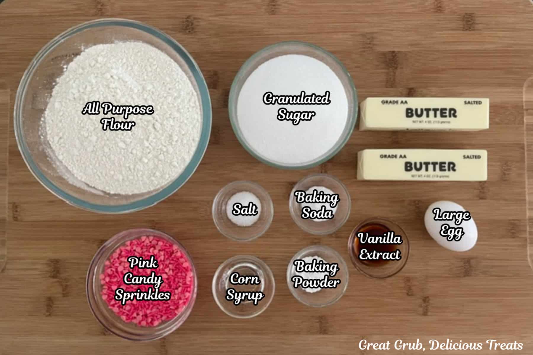 A wood surface with all the ingredients placed on it to make breast cancer sugar cookies.