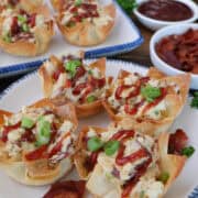 A white plate with blue trim with four chicken bacon ranch wonton cups on it with more in the background, and a title overlay at the top.
