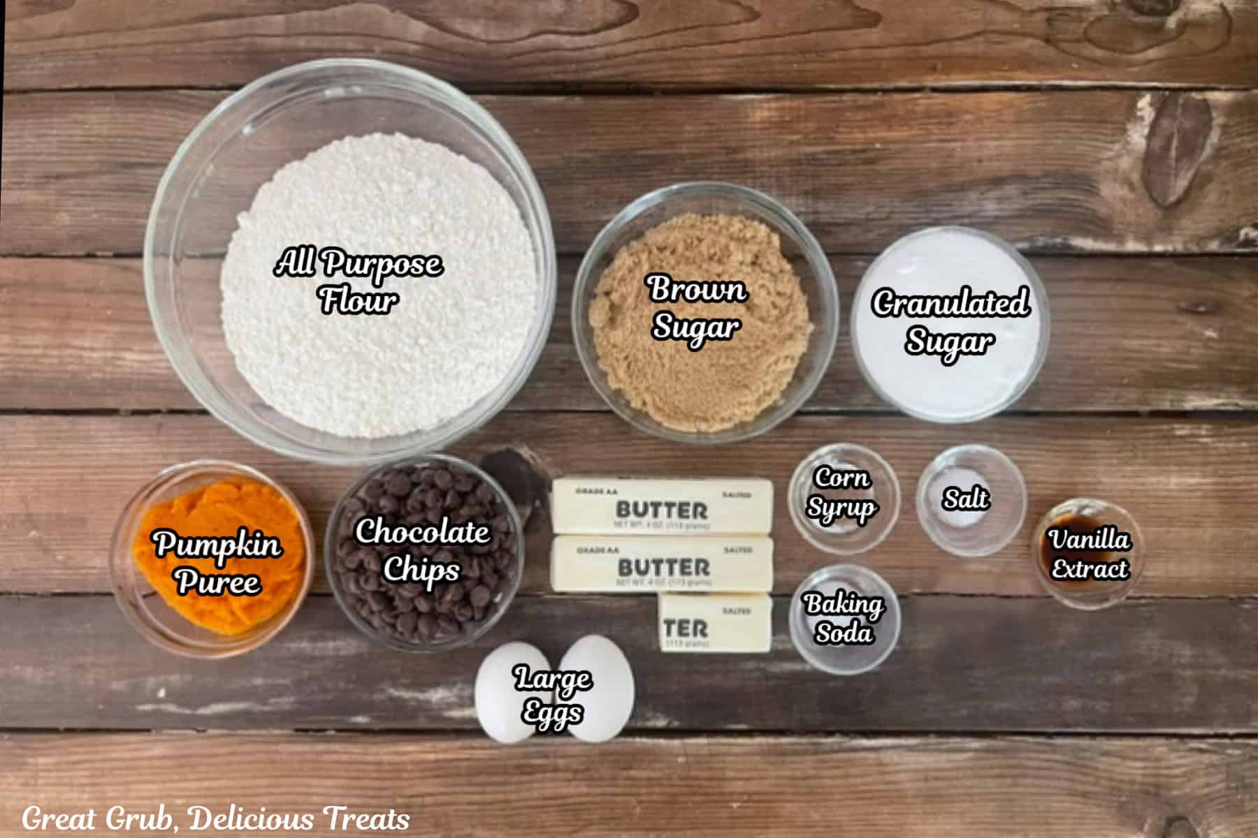 A rustic wood surface with all the ingredients placed on it to make chocolate chip pumpkin cookies.