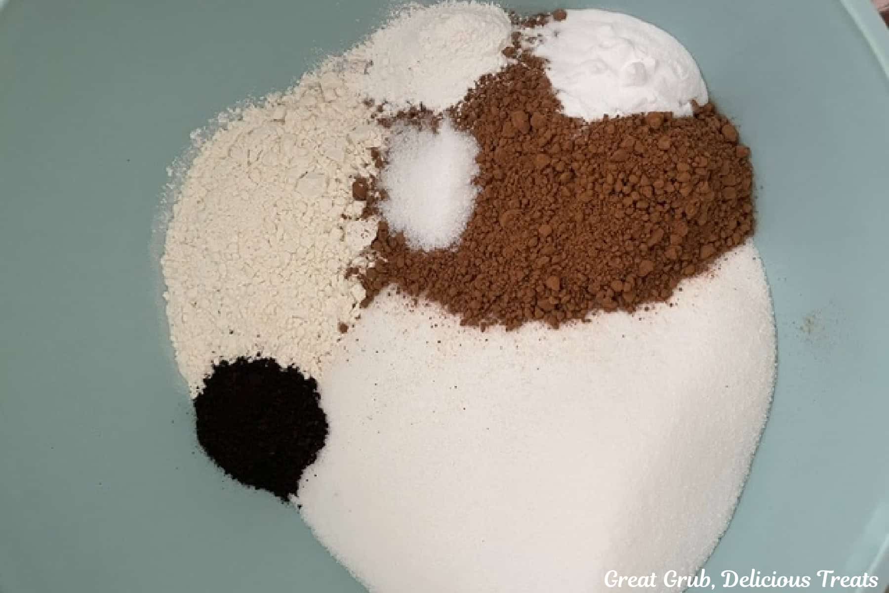 A mixing bowl with dry ingredients for chocolate cupcakes in it.