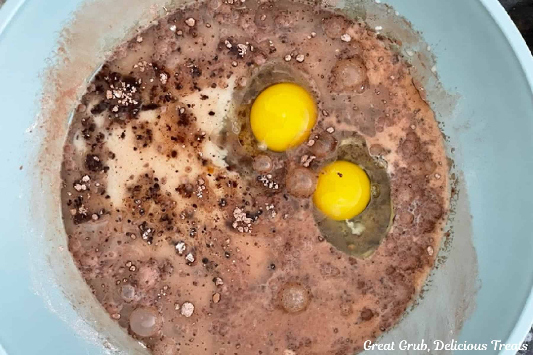 A light blue bowl with the wet ingredients for chocolate cupcakes in it before being mixed together.