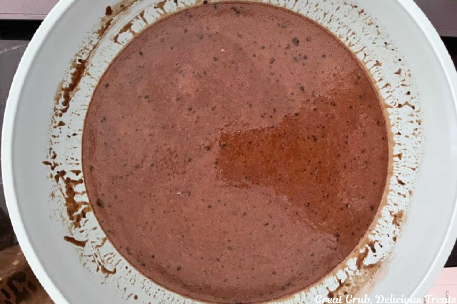 A light blue bowl with the chocolate cupcake batter in it.