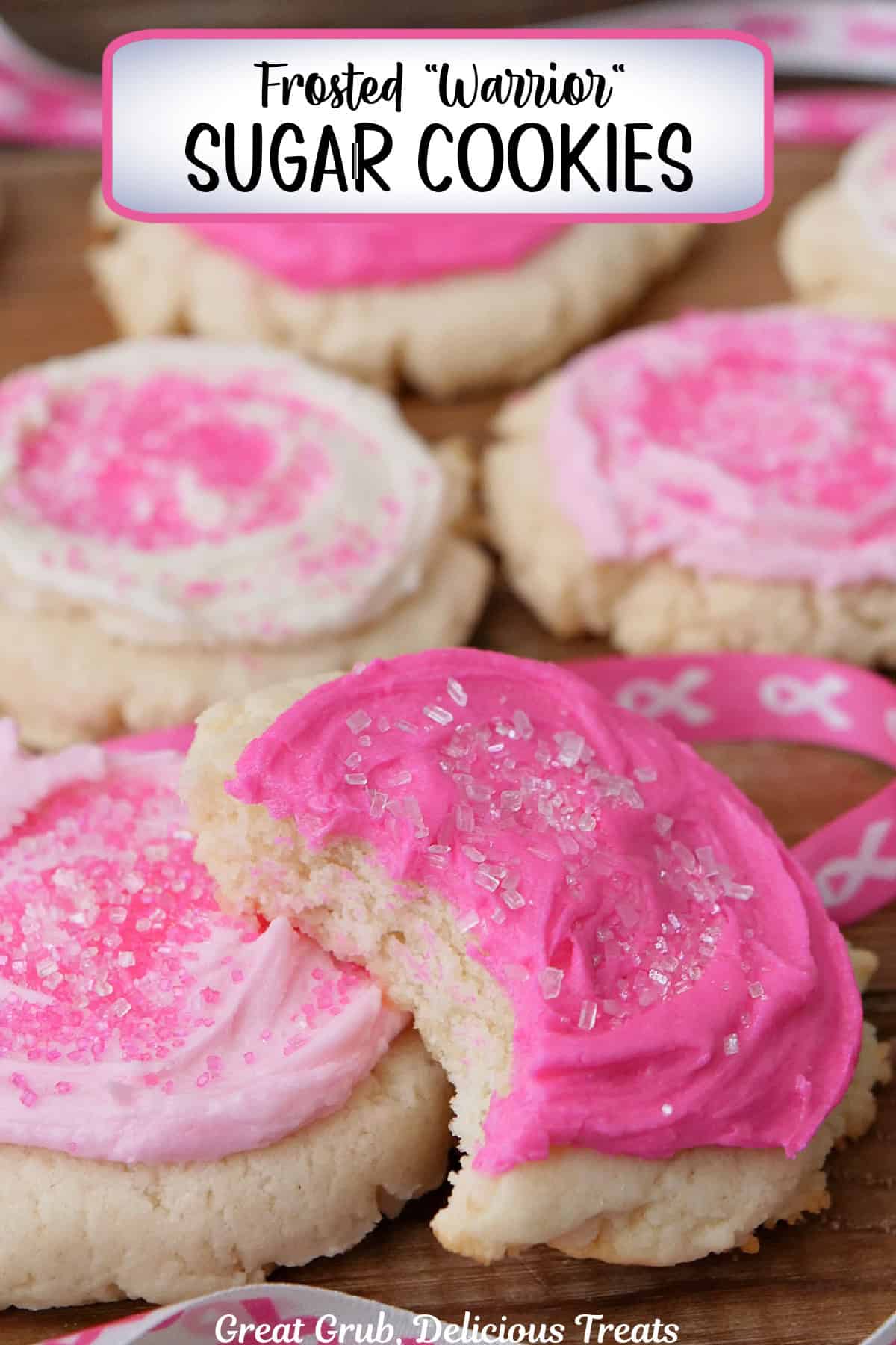 A wood surface with five pink and white frosted sugar cookies placed on it with a bite taken out of the cookie in front, and a title overlay at the top.