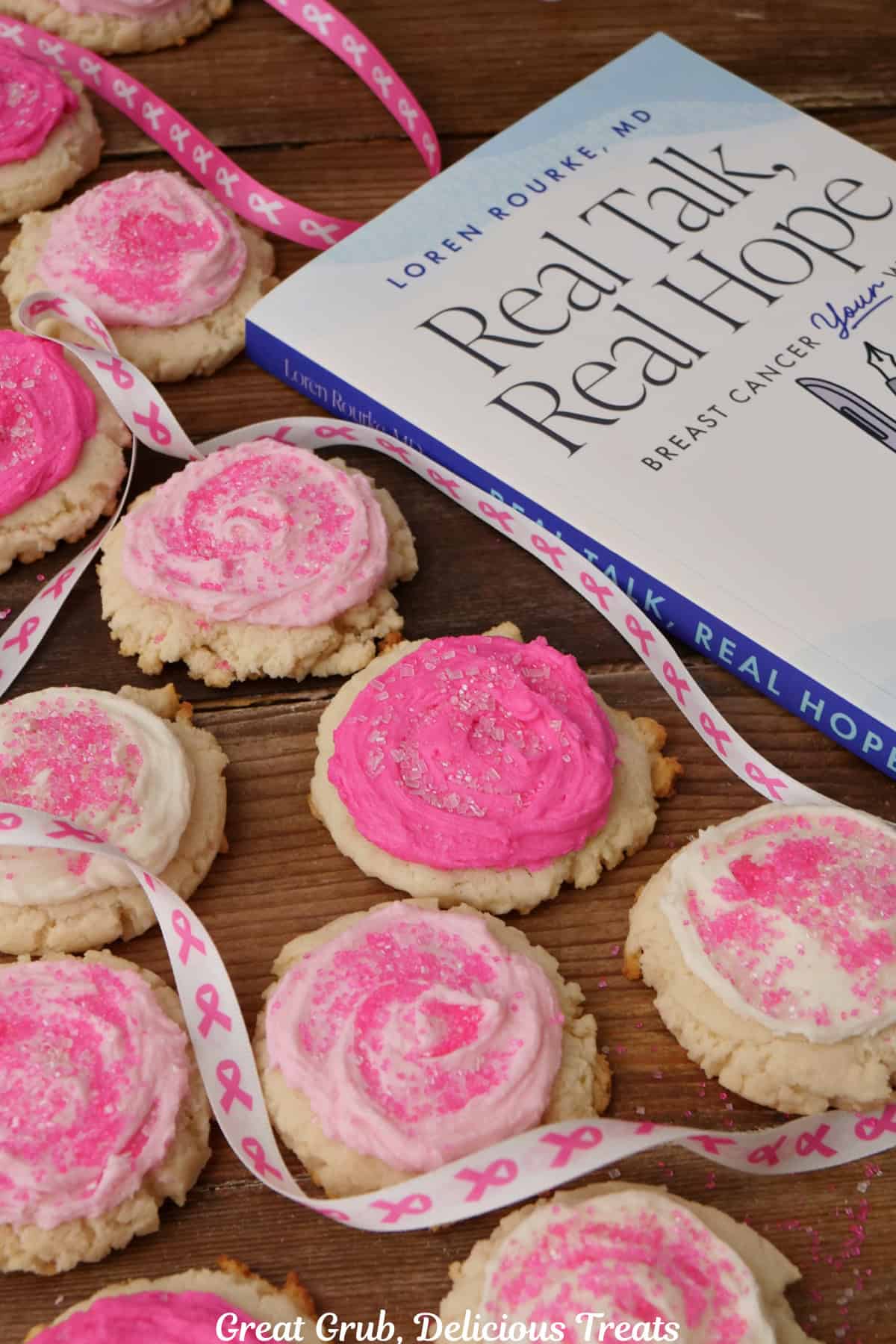 Frosted pink and white sugar cookies with the book, "Real Talk, Real Hope" off to the right side.
