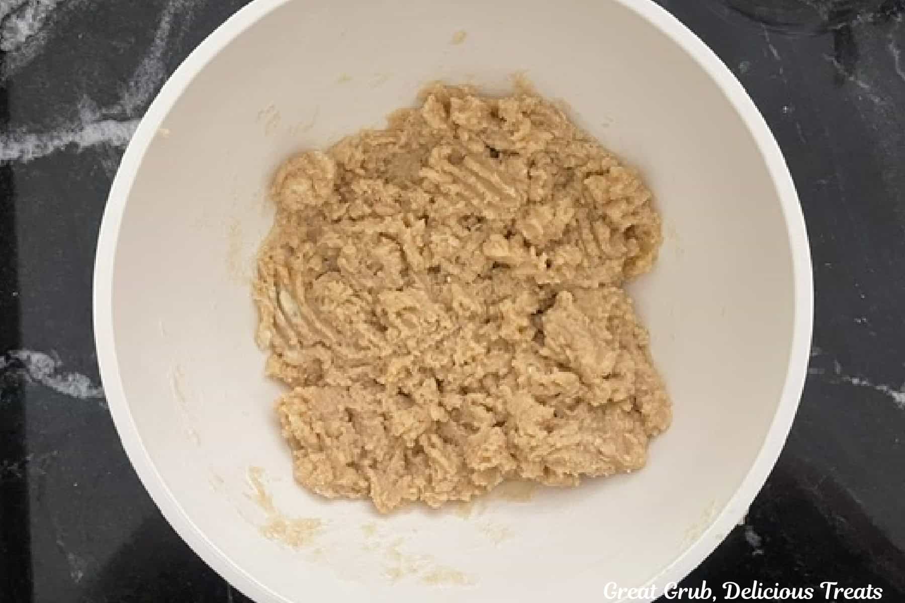 A mixing bowl filled with cobbler topping mixed together.