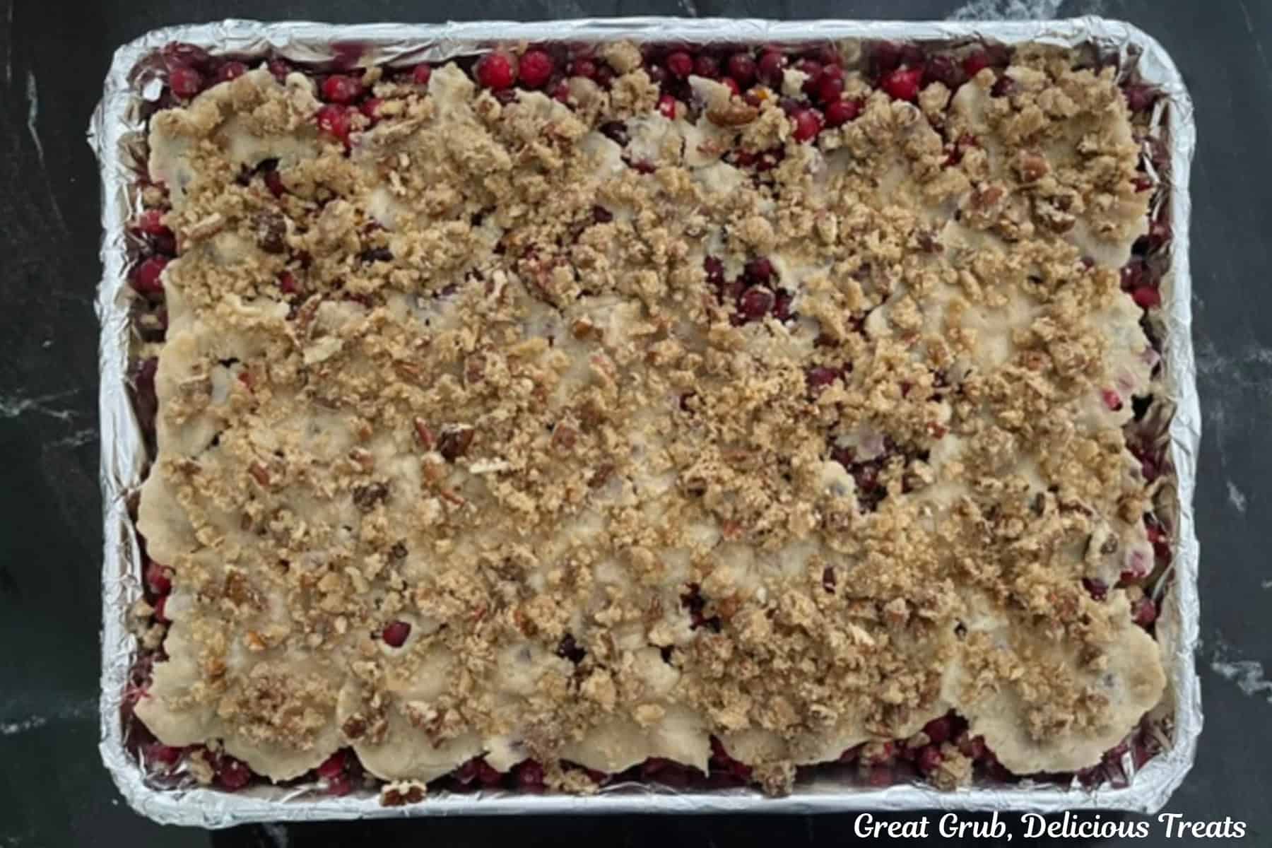 A foil lined baking sheet with cranberry orange cobbler on it before going in the oven.