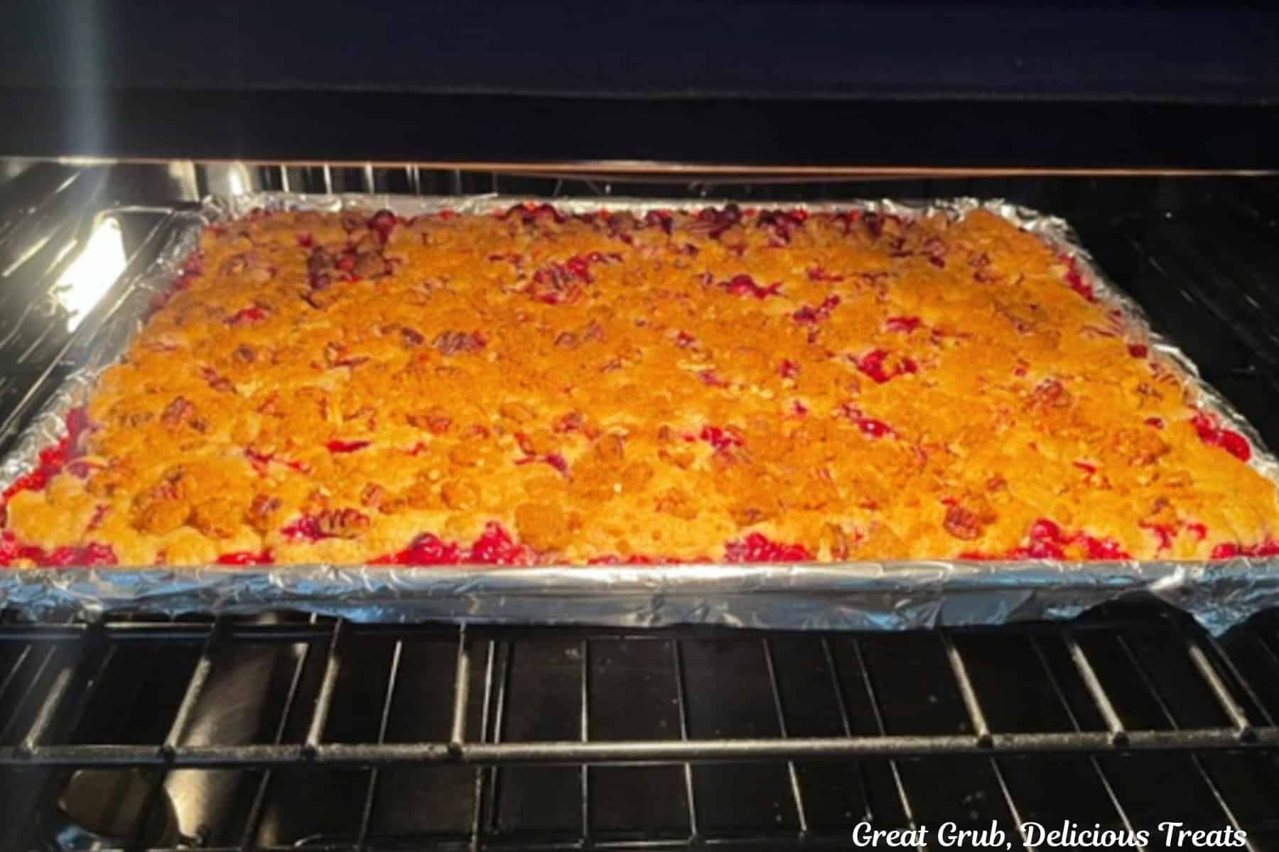 A sheet pan cranberry orange cobbler baking in the oven.